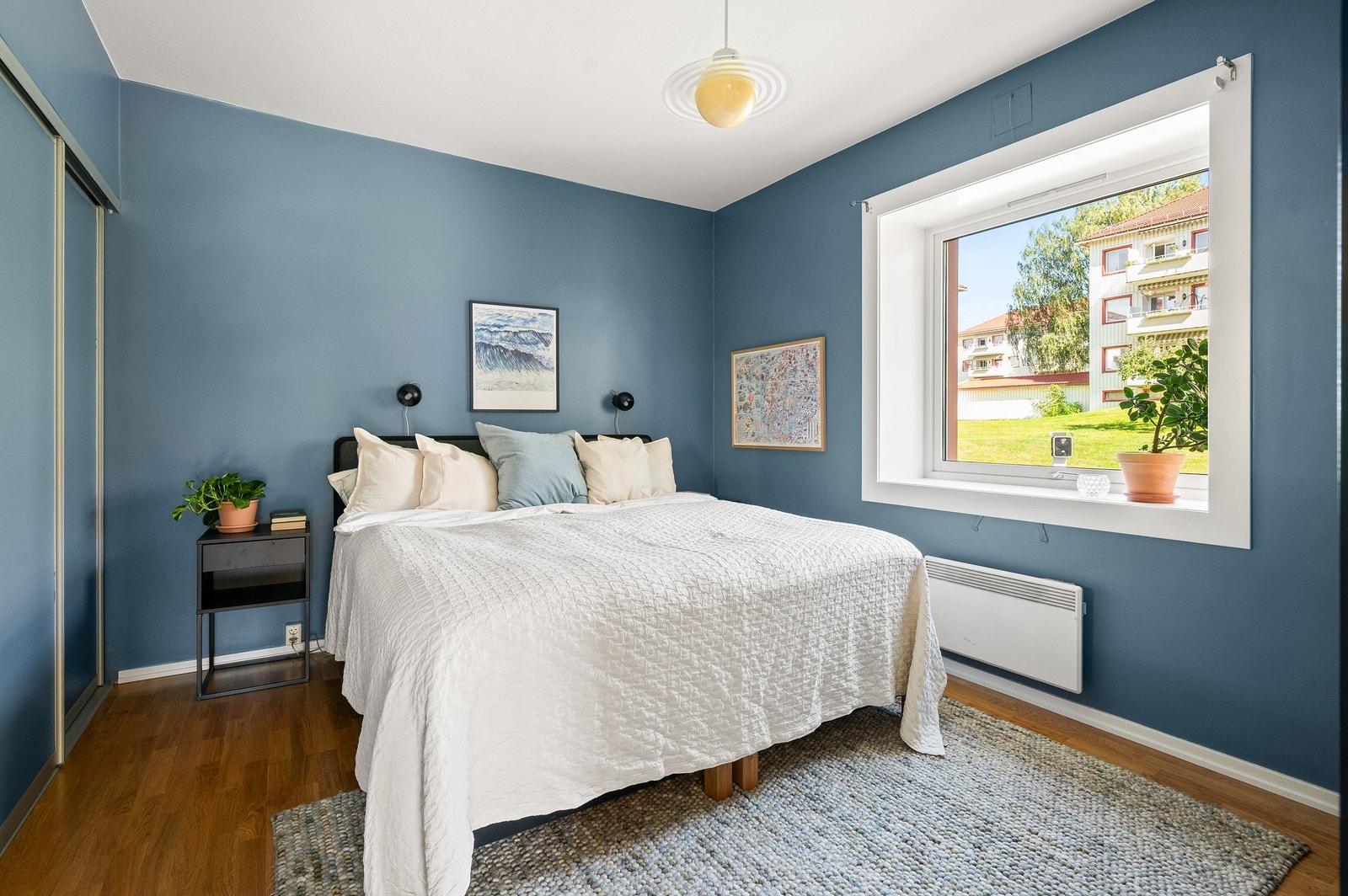 Et romslig og hyggelig hovedsoverom med god plass til stor seng og nattbord Galleribilde