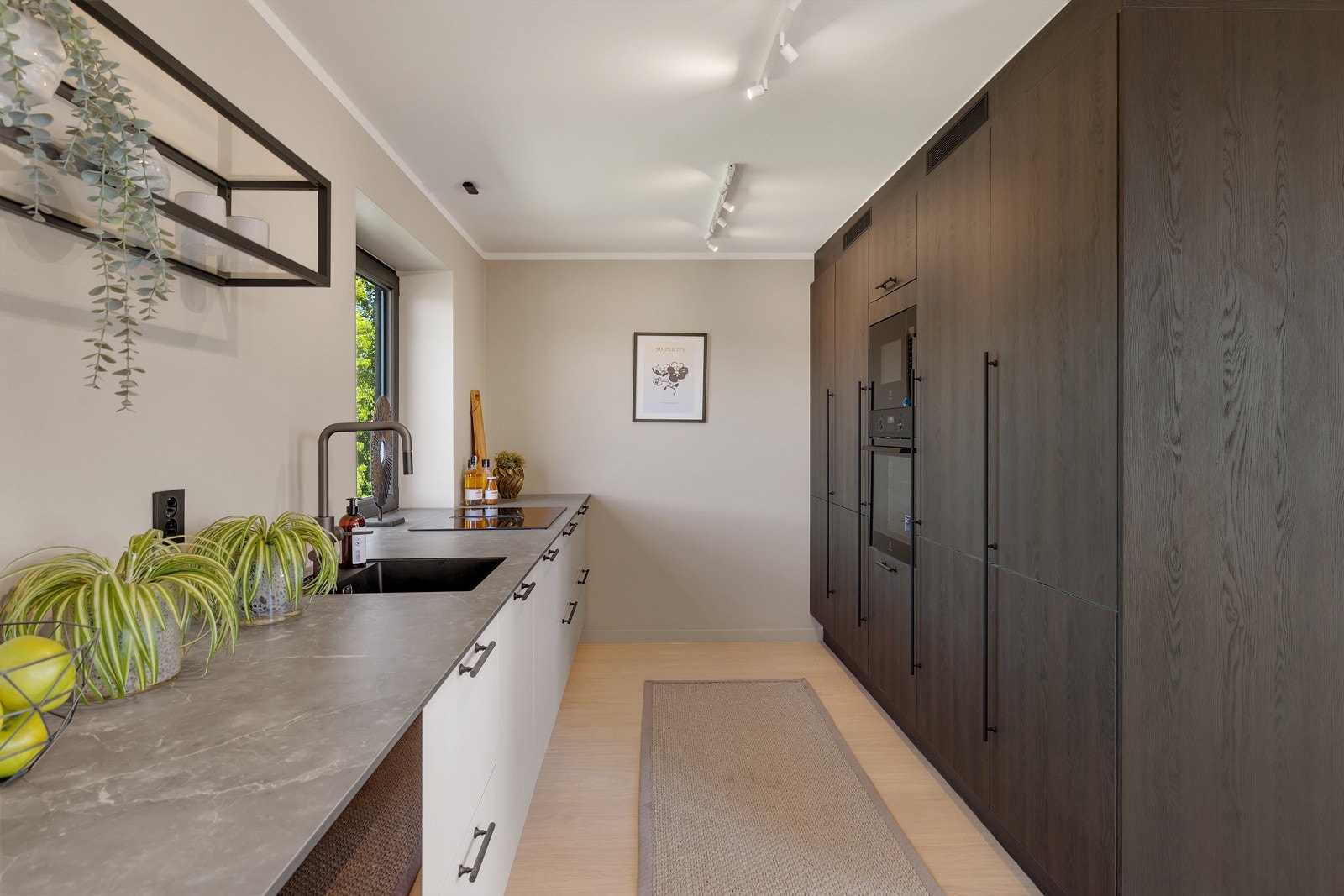 Boligen har et moderne og stilrent kjøkken som er en del av en åpen løsning mot stuen. Galleribilde