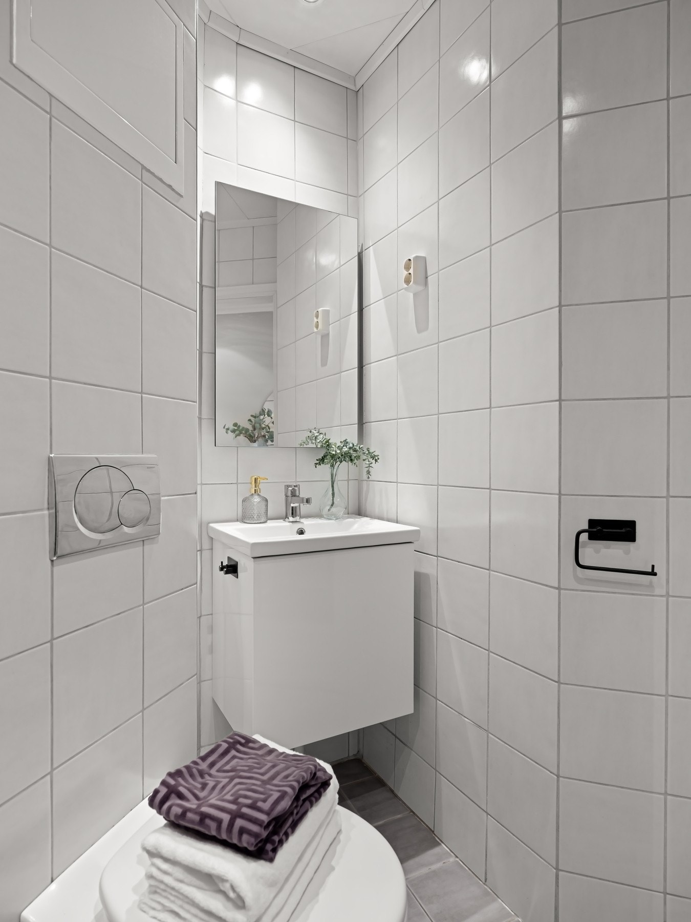 Dusjhjørne med innfellbare glassdører, vegghengt toalett, ny servant og plass til vaskemaskin - et praktisk og funksjonelt bad. Galleribilde