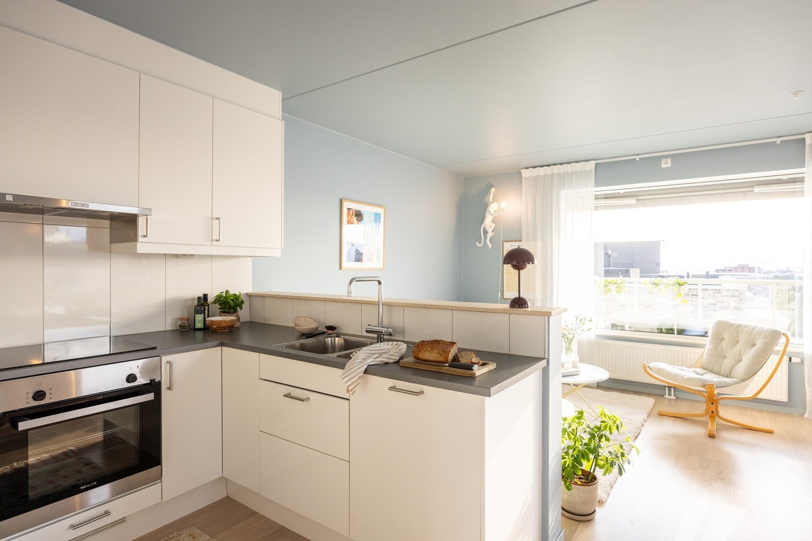 Kjøkkeninnredningen består av glatte, hvite fronter og benkeplate av laminat med med nedfelt vask- og skyllekum. Galleribilde