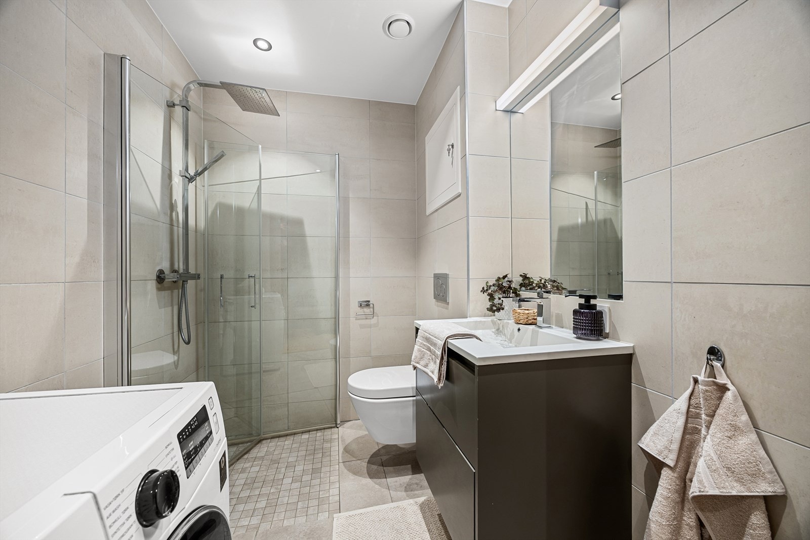 Lekkert flislagt bad med gulvvarme og downlights Galleribilde