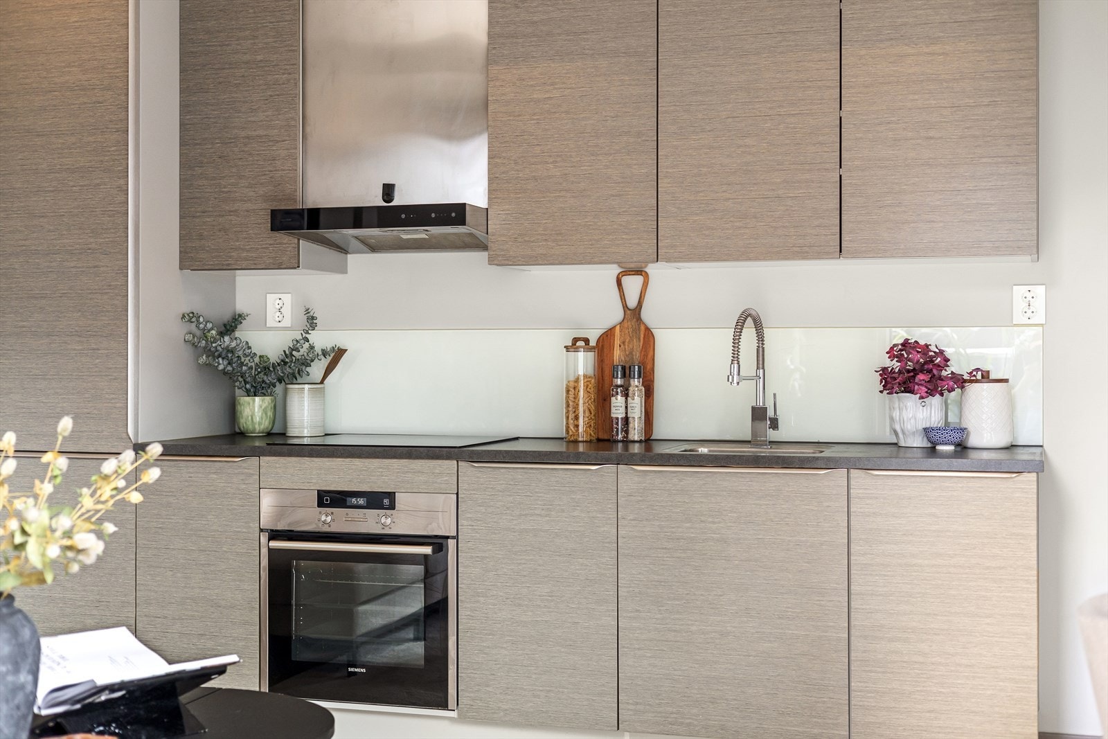 Kjøkken utstyrt med integrert kjøl/frys, platetopp, komfyr, oppvaskmaskin og avtrekksvifte Galleribilde