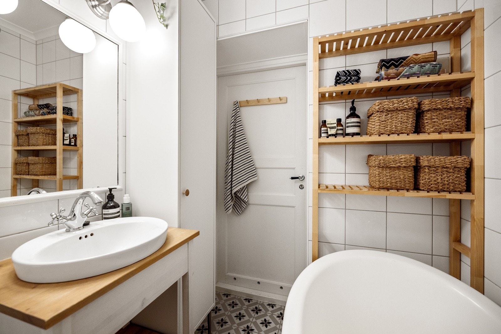 Badet består av badekar, servant med underskap, vegghengt skap og toalett Galleribilde