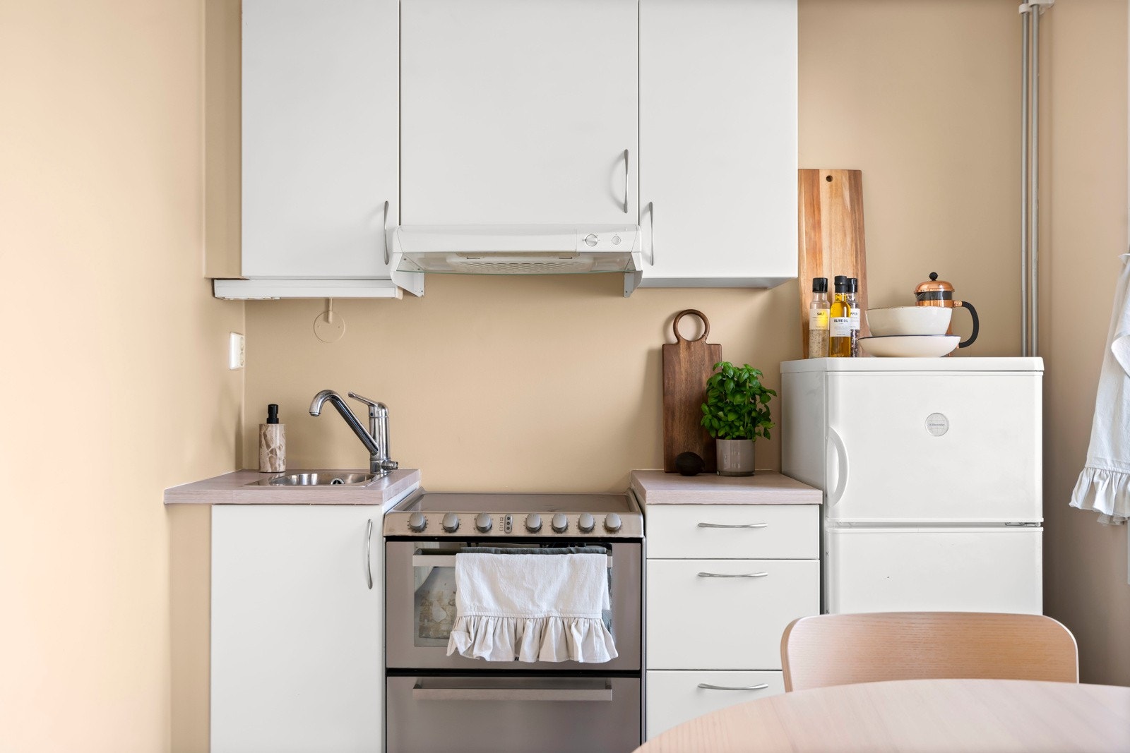 Åpen og moderne kjøkkenløsning med tidløse farger. Frontene er glatte og folierte, med benkeplate i slitesterk laminat. Galleribilde