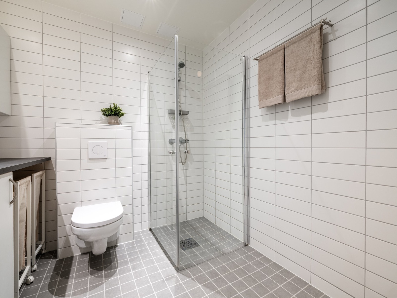 Videre er det vegghengt toalett og dusjhjørne med svingbare dører som frigjør plass på gulvet. Galleribilde