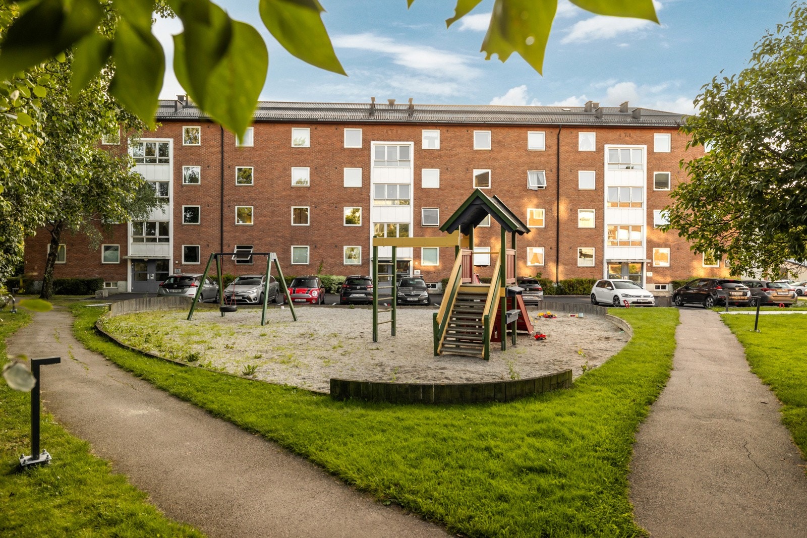 Her er det stor plen, benker og variert lekeplass som huskestativ, sandkasse, og klatrestativ med sklie - perfekt for familier med barn Galleribilde
