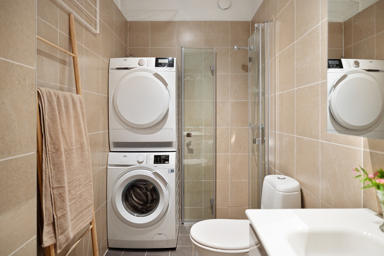 Baderommet er også utstyrt med dusjhjørne med innfellbare glassdører og gulvstående toalett. I hjørnet er det plass og opplegg for vaskemaskin, samt tørketrommel over om ønskelig. Galleribilde