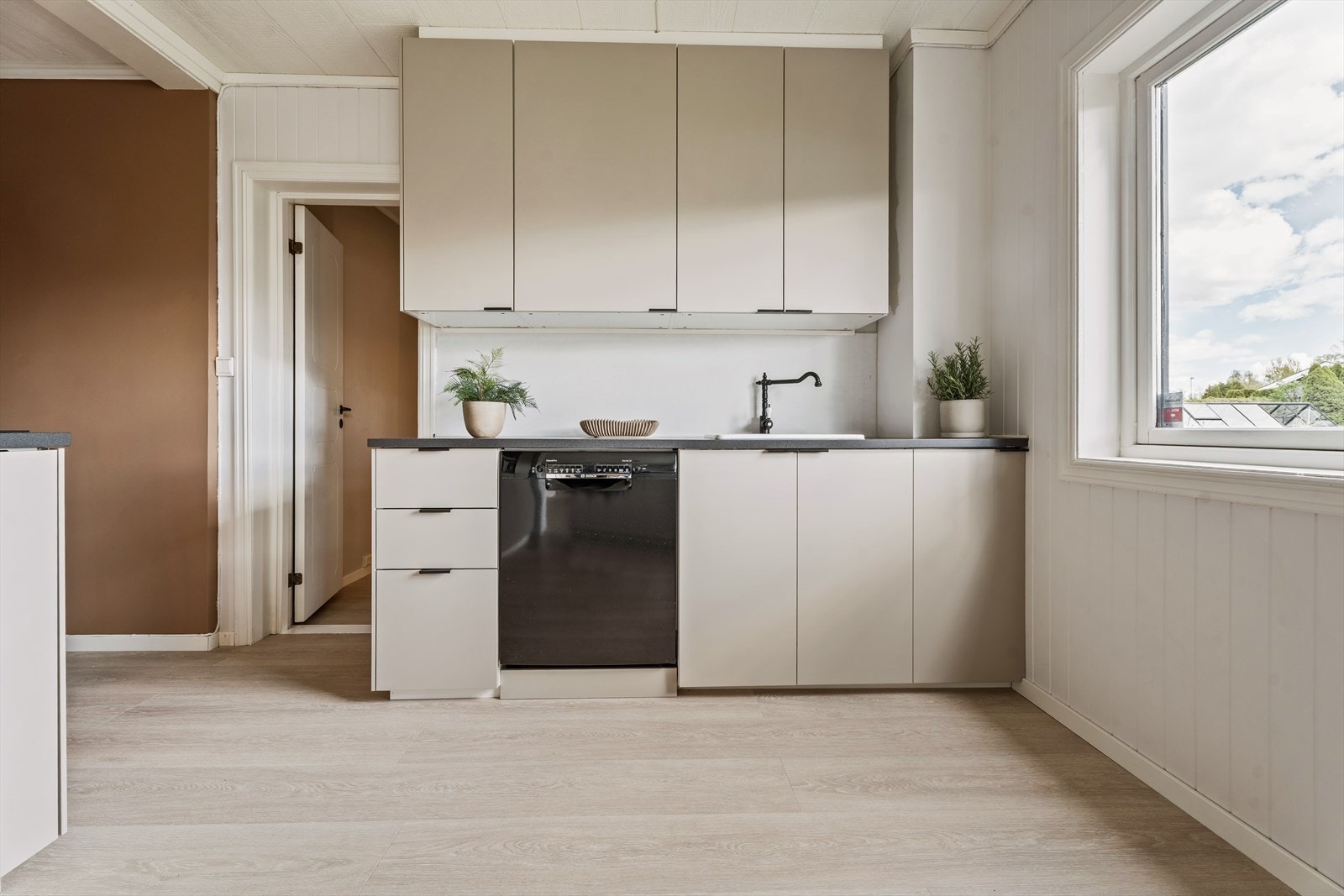 Hvitevarene er for det meste integrerte og i mørk benkeplate er det nedfelt oppvaskkum med klassisk kran. Galleribilde