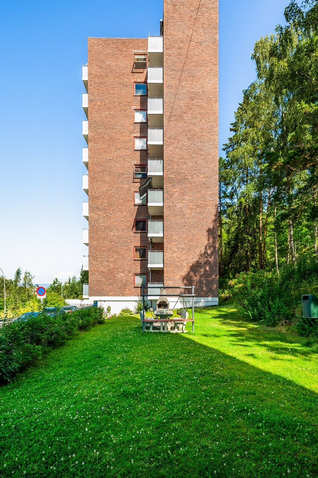 Pent opparbeidet fellesareal med sittegruppe, omgitt av frodig beplantning. Galleribilde