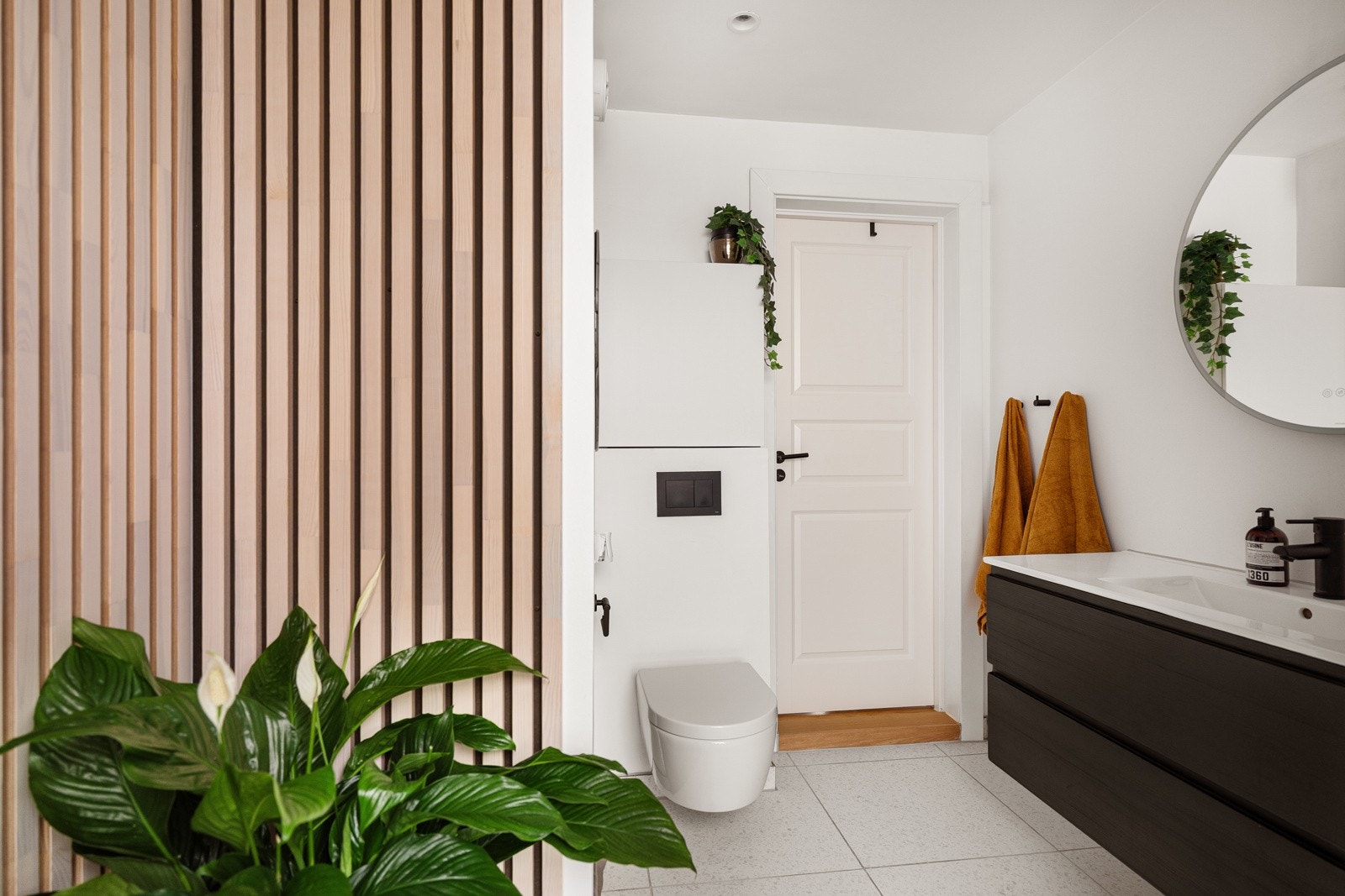 Det er flislagt gulv, og vegger utført med fliser i dusjsonen, glatte malte flater samt spiler. Galleribilde