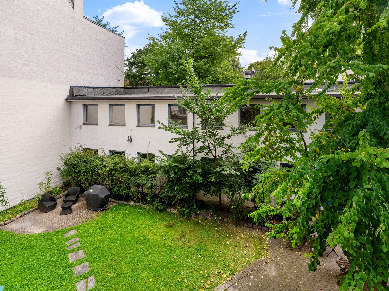 Balkongen vender mot grønn og pent opparbeidet bakhage. Galleribilde