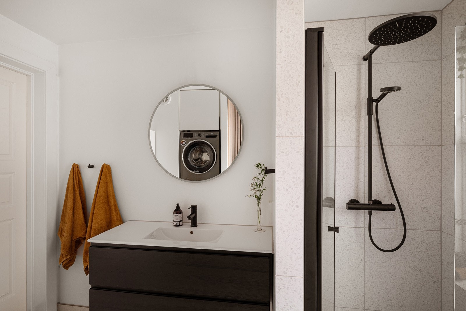 Baderommet har vegghengt servantinnredning, speil på vegg med lys og stikkontakt over servant. Galleribilde