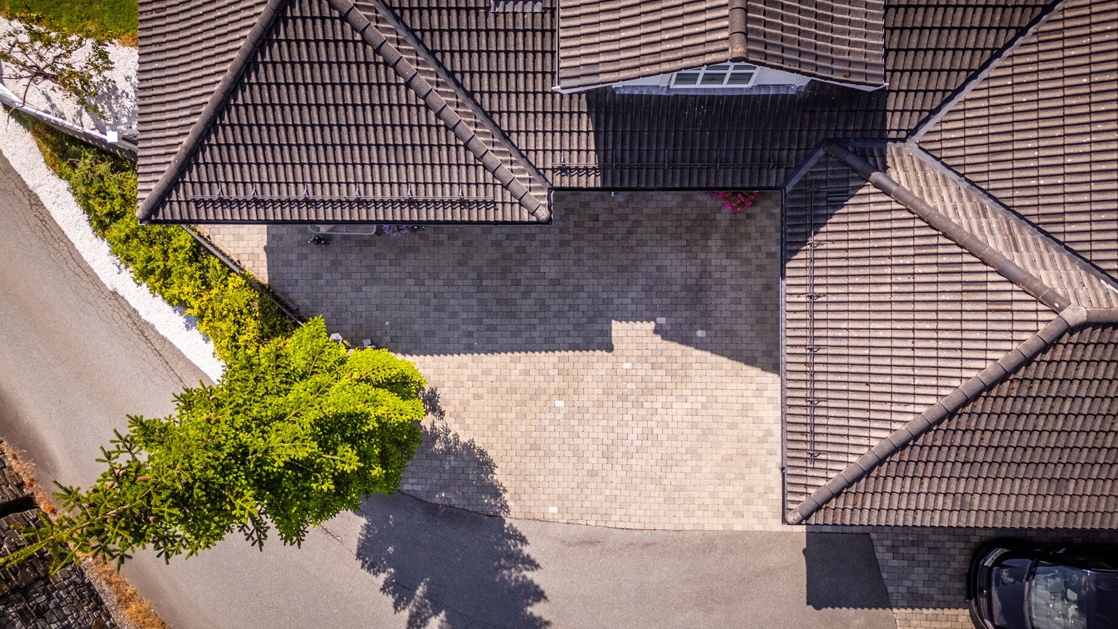 - Foran inngangspartiet gir det steinbelagte tunet et pent førsteinntrykk, samtidig som det er praktisk for bilvask og annet - Galleribilde