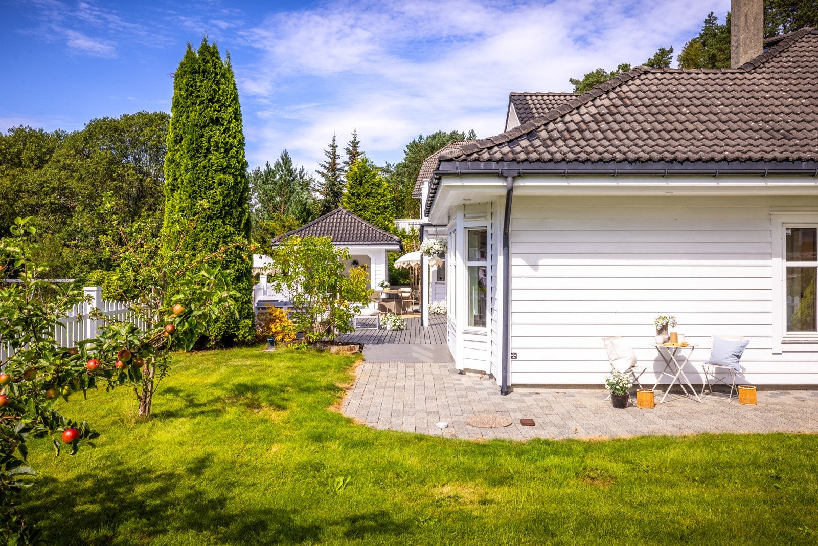 - Tomten er flat og lettstelt, med plen, epletrær, kirsebærtre og blomsterbed. - Galleribilde