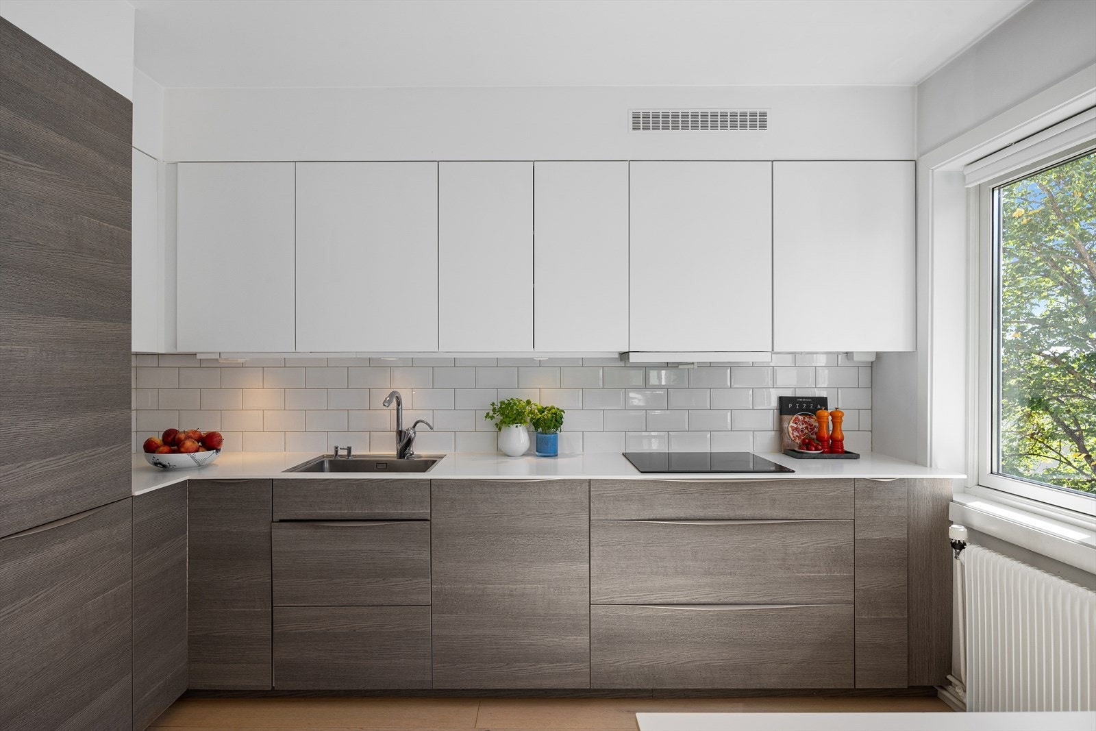 Kjøkkenet er komplett utstyrt med integrerte hvitevarer: koketopp, stekeovn, mikro, oppvaskmaskin samt kjøl- og fryseskap. Galleribilde