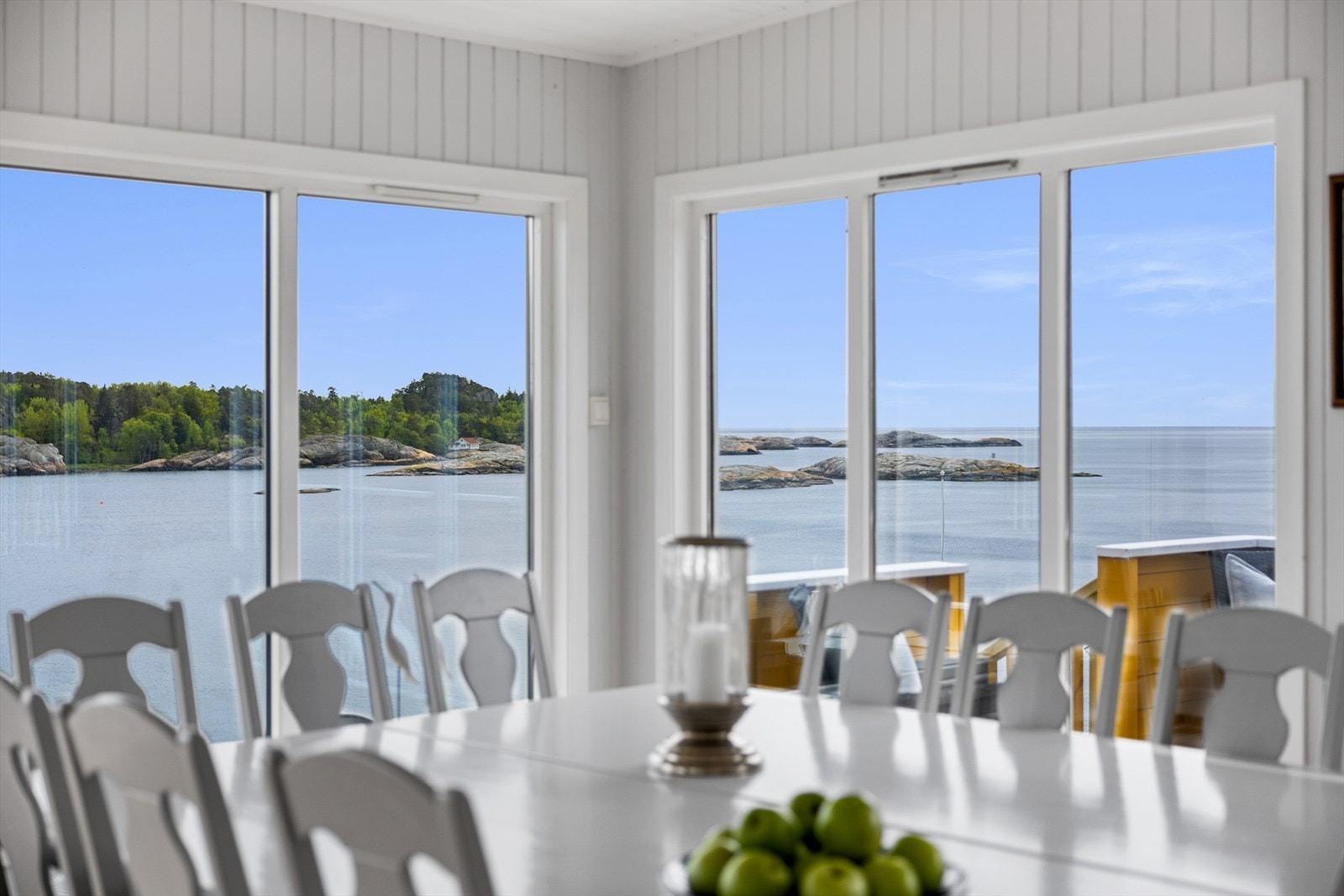 Vindusrekke på tre sider bader stuen i dagslys og gir en nydelig og langstrakt fjordutsikt. Galleribilde