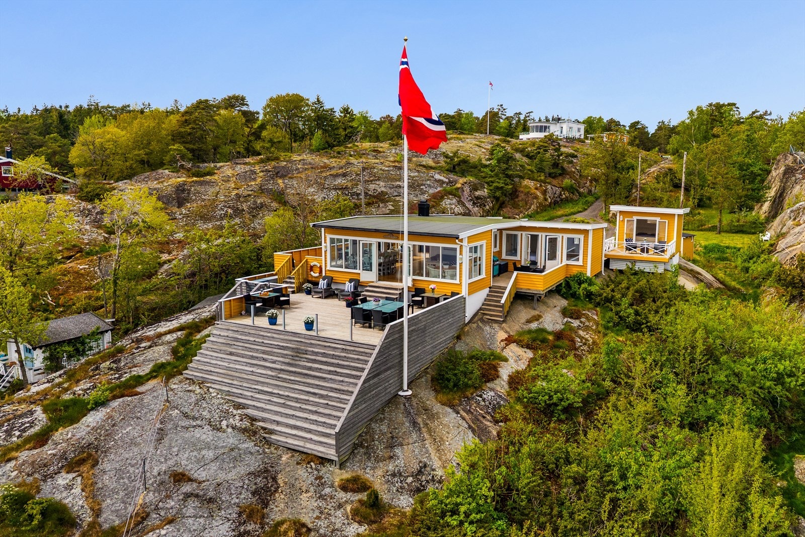 Hytta ligger fint i terrenget, høyt på tomten med panorama over sjøen. Galleribilde