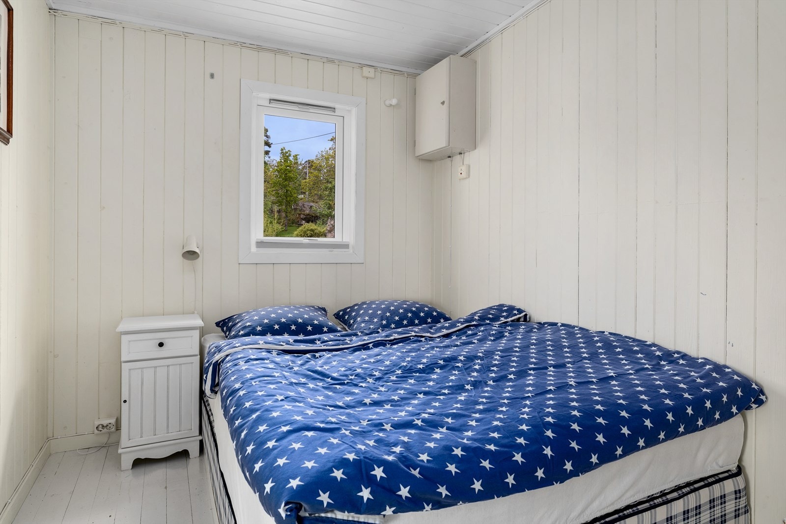 Det ene soverommet inne i hytta har malt gulv og alle har lysmalte paneloverflater. Galleribilde