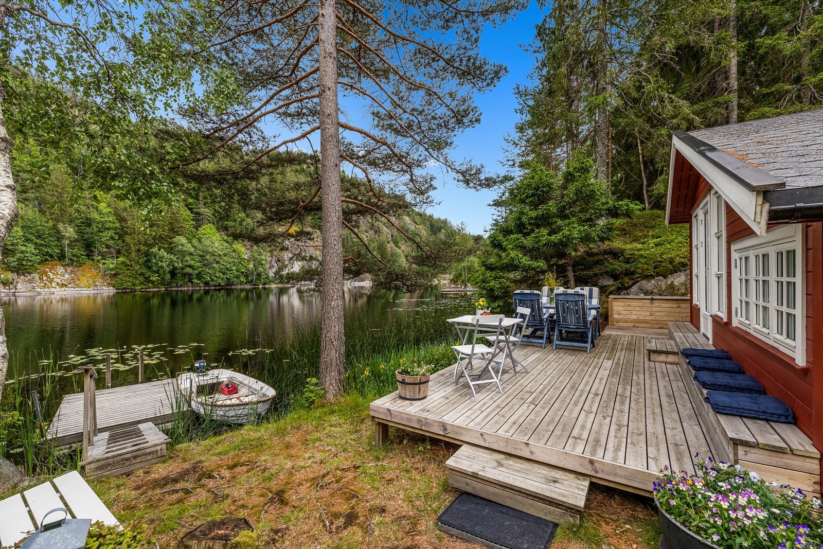 Fra terrassen går det en rampe ned til vannkanten, hvor det er herlige bademuligheter, samt plass til båten. Galleribilde