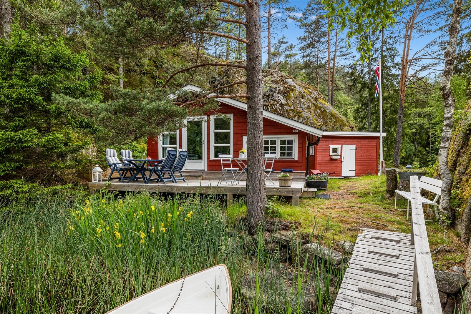 Fritidseiendommen ligger omkranset av skog og oppleves som en fredelig, skjermet perle. Galleribilde