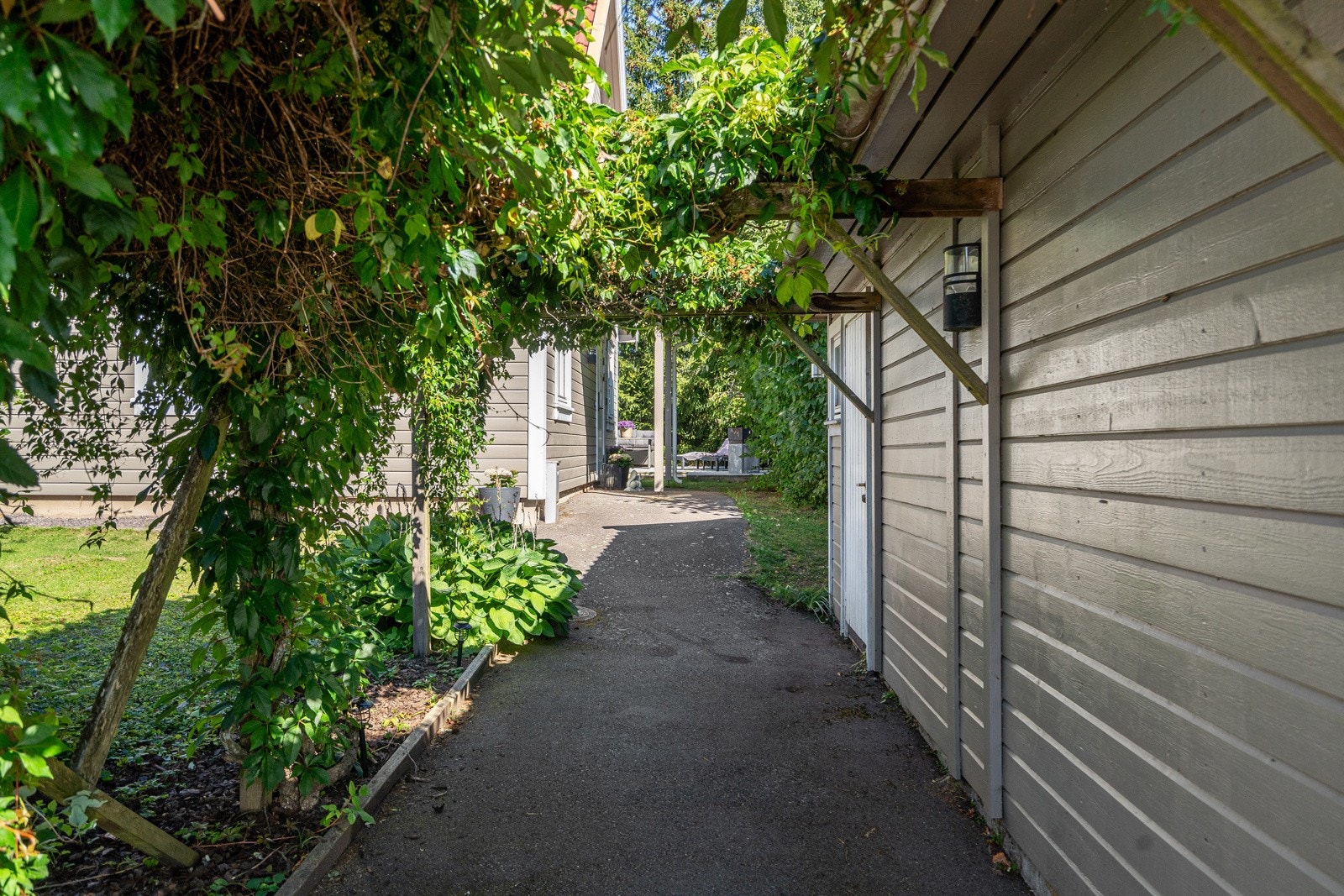 Asfalterte internveien og flott beplantning rundt boligen Galleribilde