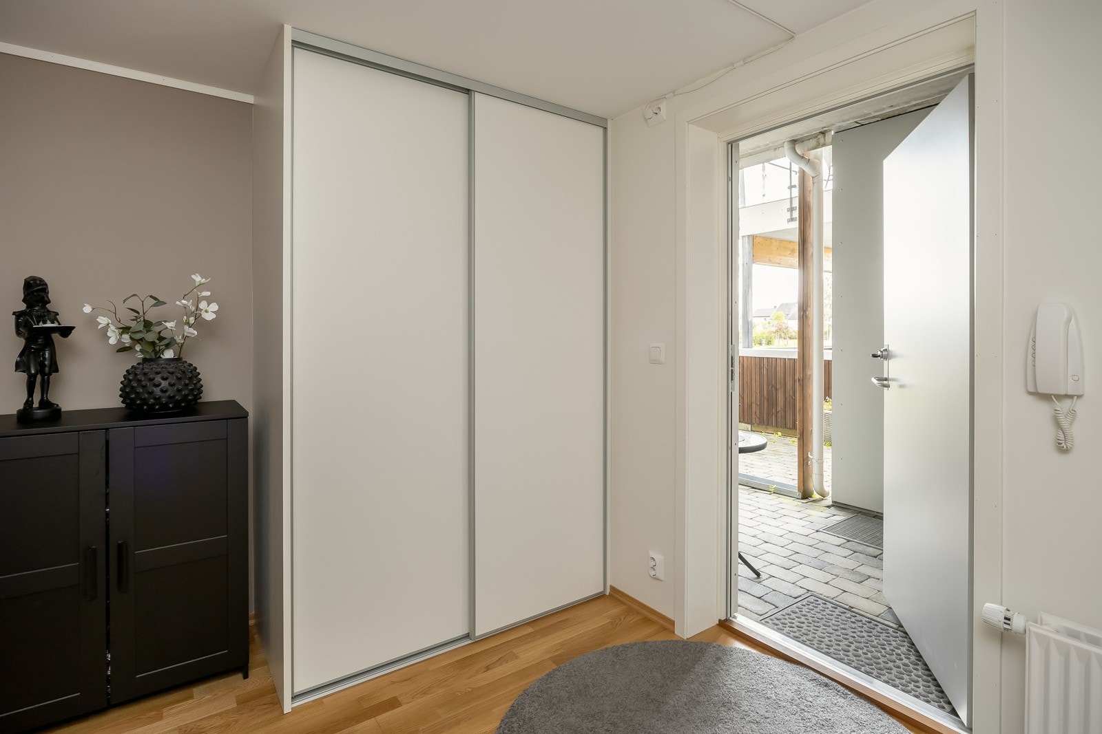 Man ønskes inn i en romslig og lys entrè med god plass til ytterklær og sko. Et garderobeskap er etablert i entrèen og følger med i handelen. Galleribilde