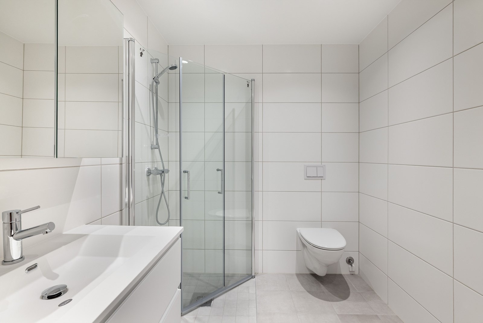 Baderommet er også utstyrt med dusjhjørne med innfellbare glassdører og vegghengt toalett. Galleribilde