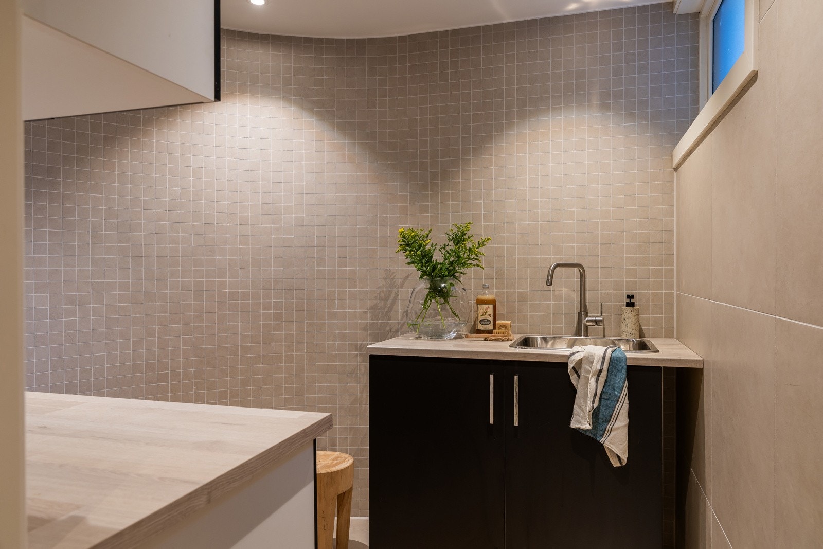 Utstyrt med en praktisk vask, godt med benkeplass og smarte skapløsninger for ekstra lagring. Lyse fliser på både gulv og vegger som gir rommet et friskt og moderne preg. Galleribilde