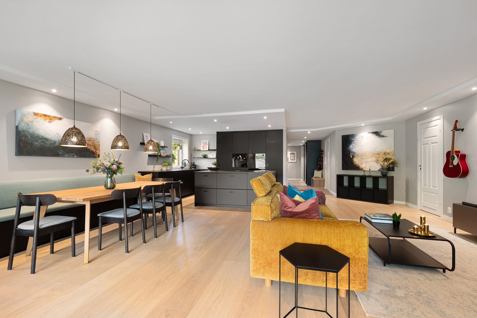 Spottene er strategisk plassert langs veggene og over kjøkkensonen, noe som både bevarer takhøyden og gir god belysning. Galleribilde