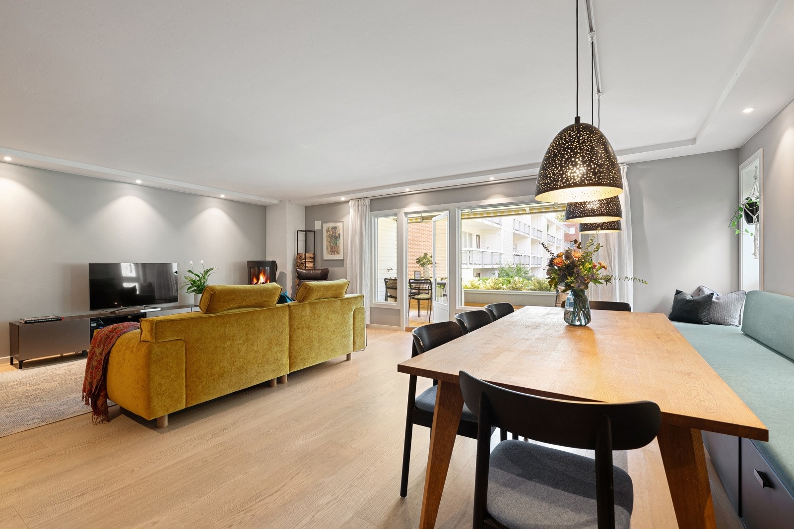 Stor og sosial stue med rikelig dagslys fra store vindusflater. Galleribilde