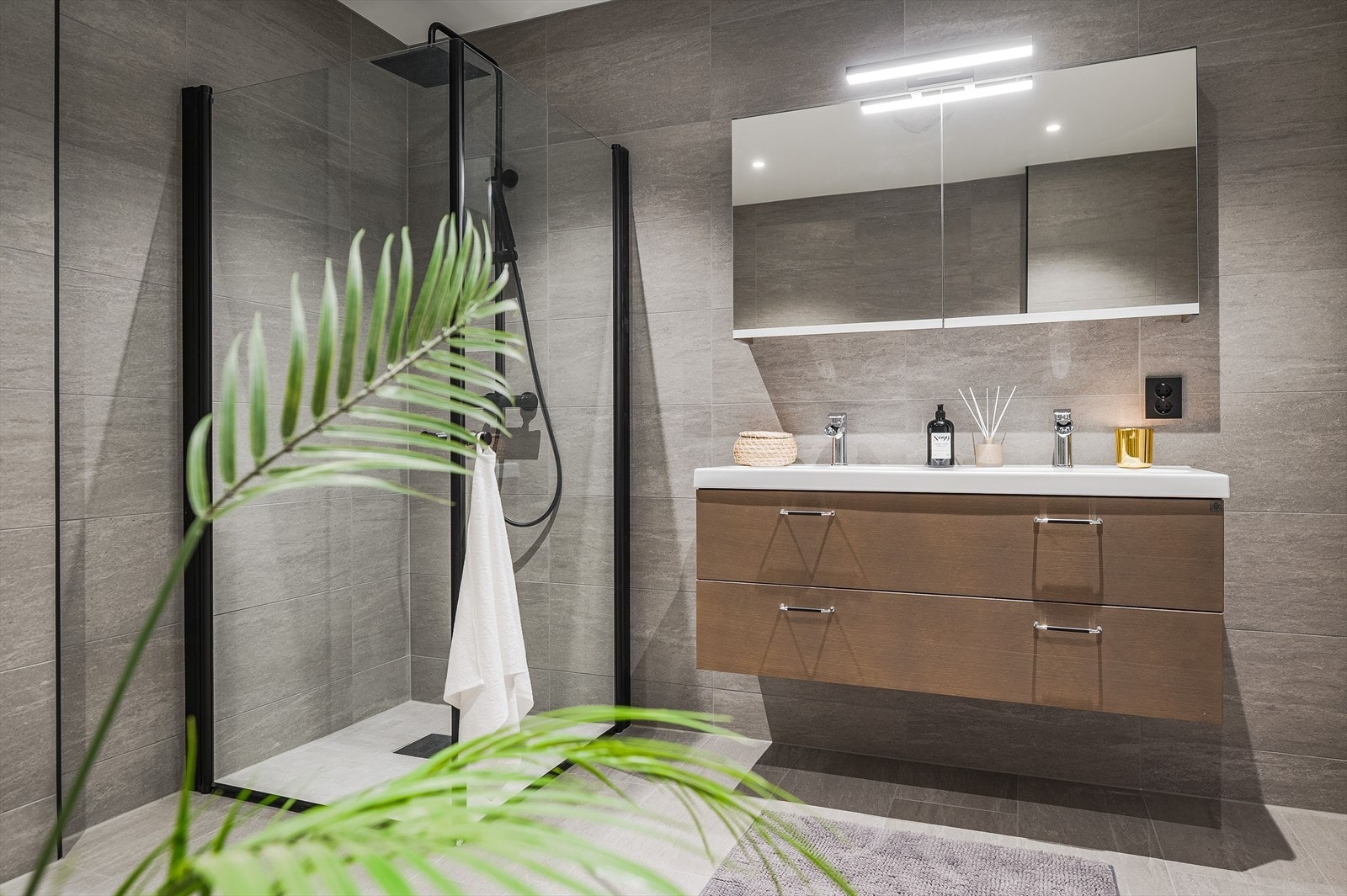 Badet ligger i første etasje og er meget innbydende. Det er flislagt, har varme i gulvet og dobbeltservant med underskap. Over servantene er det speilskap med mulighet for oppbevaring. Galleribilde