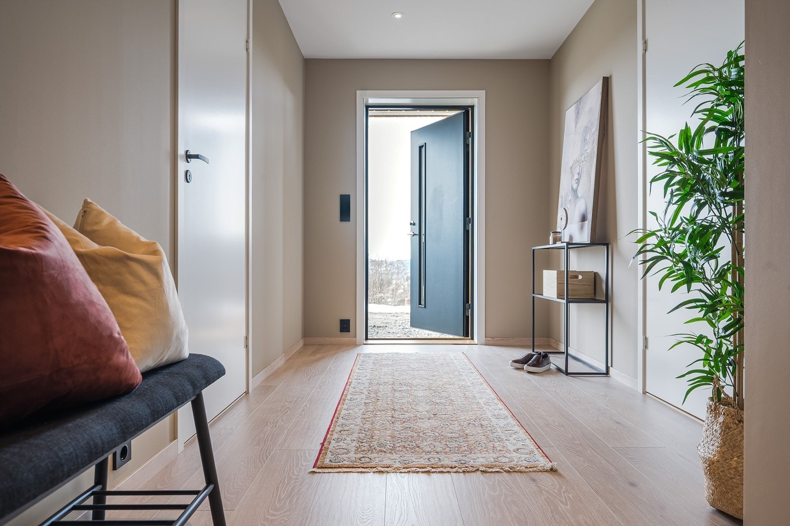 Velkommen inn. Gangen er innbydende, har laminat på gulvende og plater malt i en behagelig farge. Galleribilde