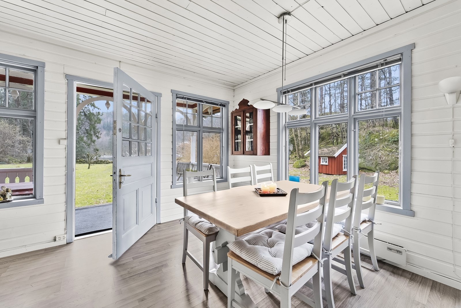 Utgang fra stua til overbygd terrasse og utsikt mot fjorden. Galleribilde