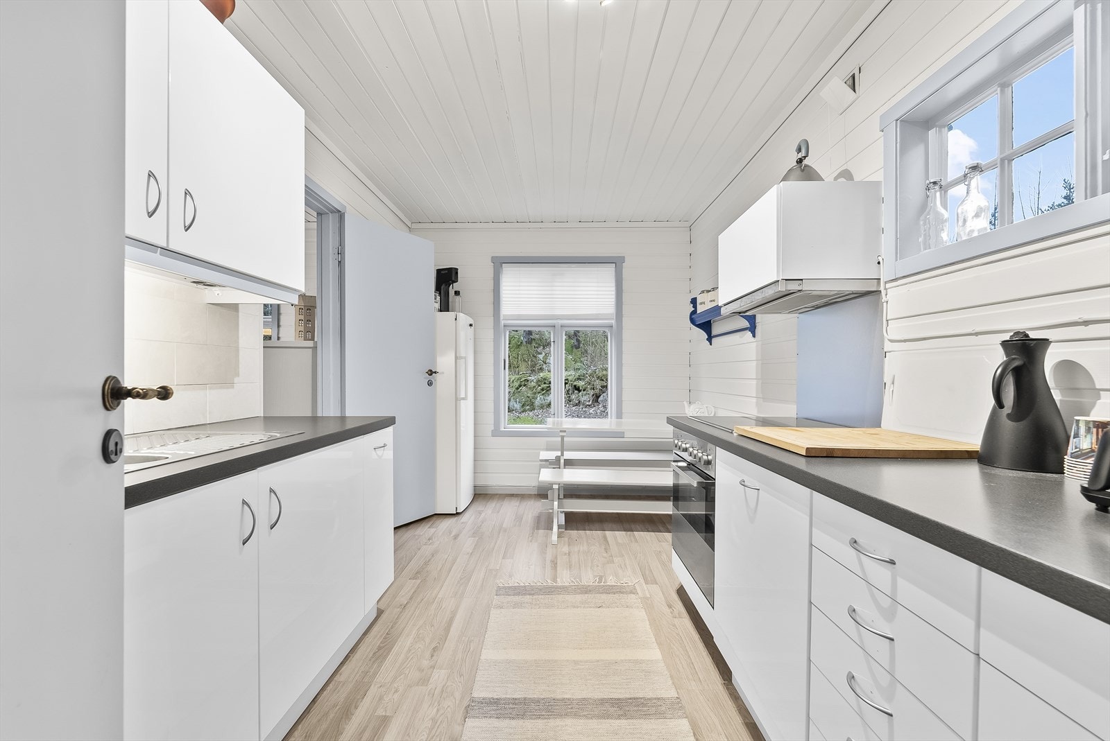 Lyst kjøkken med praktisk utnyttelse. Vinduer som gir naturlig lys. Galleribilde