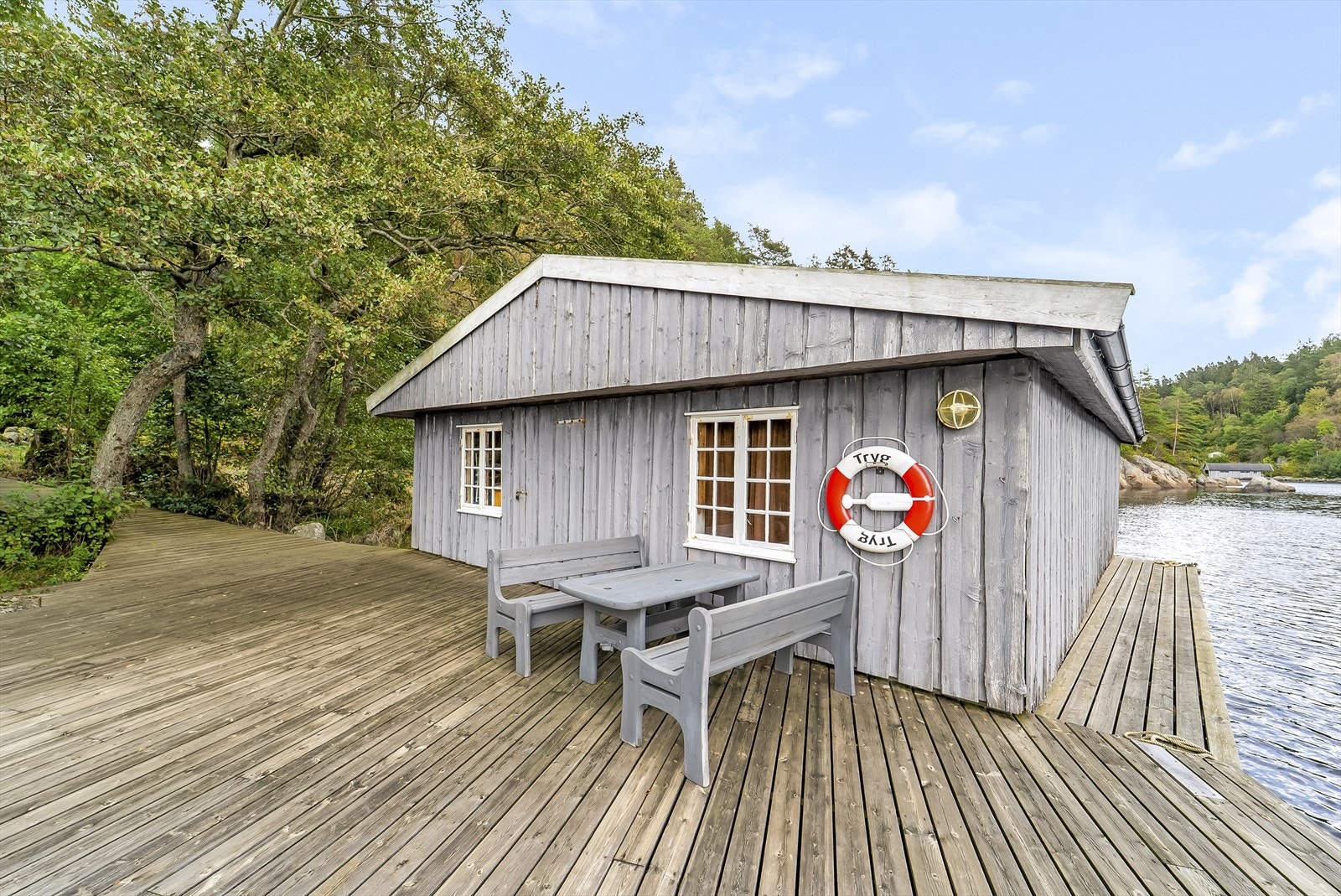 Båthus ved sjøen med stor brygge og idyllisk beliggenhet. Galleribilde