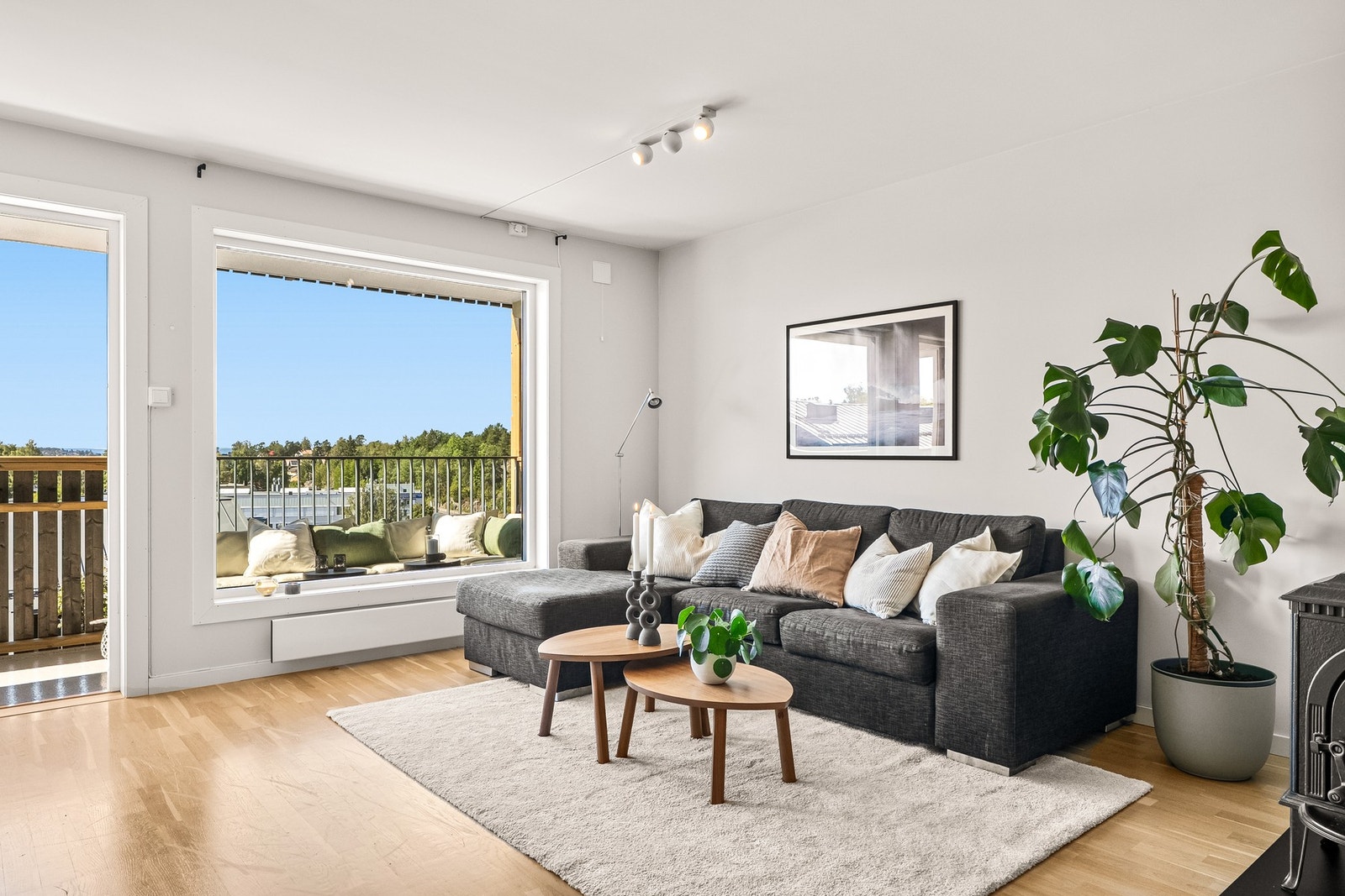 Lys stue med store vindusflater og utsikt mot natur. Galleribilde