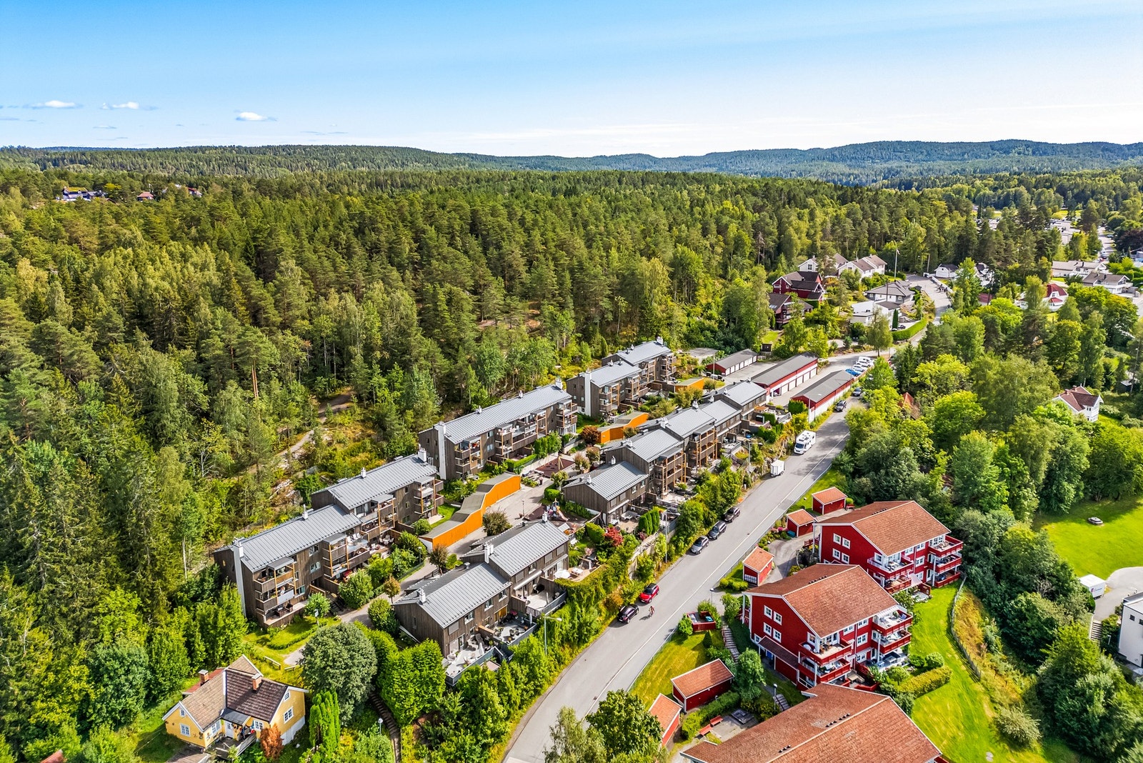 Boligområde med rekkehus og leiligheter omgitt av skog og natur. Galleribilde