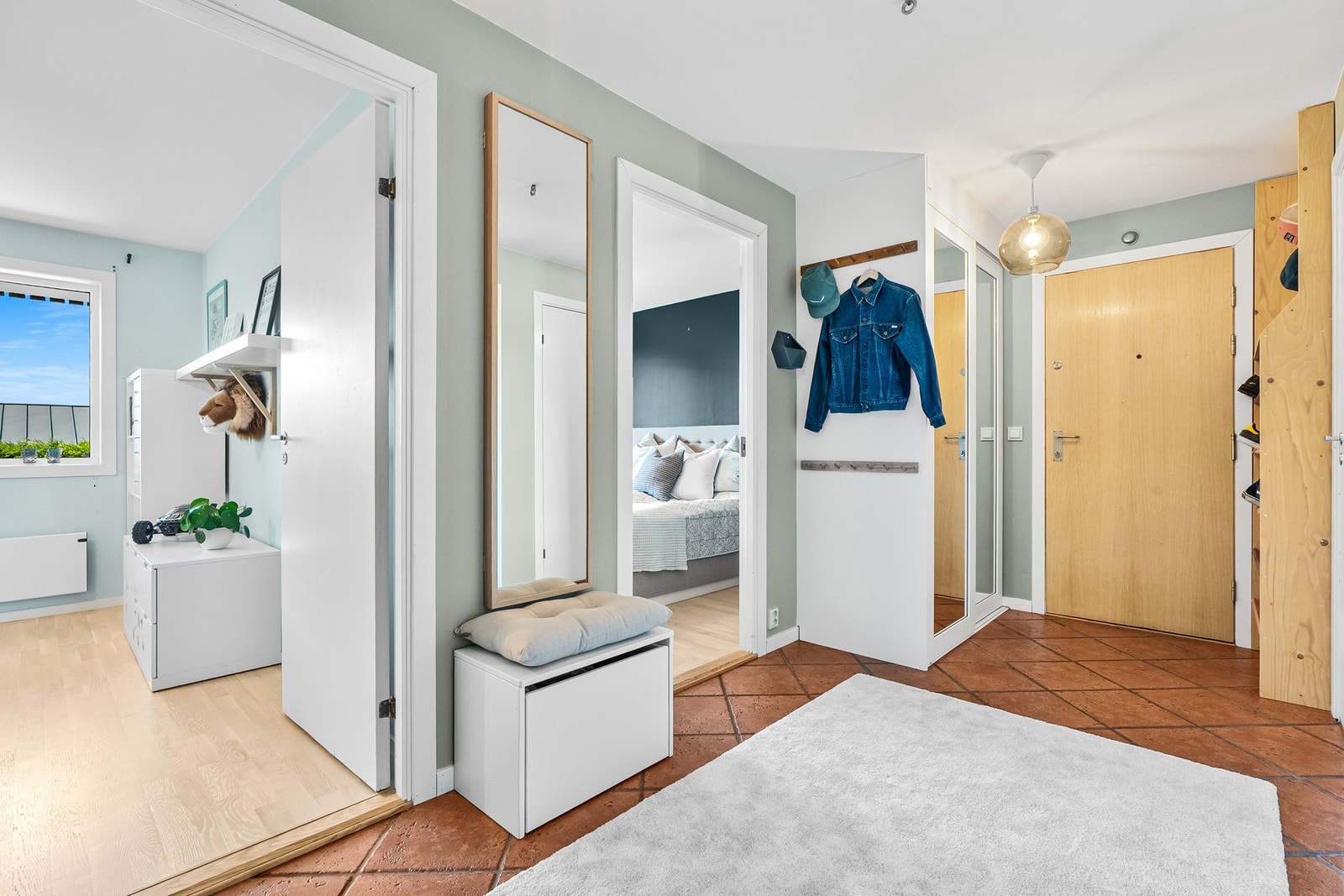 Lys og romslig gang med flislagt gulv, speil og god oppbevaringsplass. Galleribilde