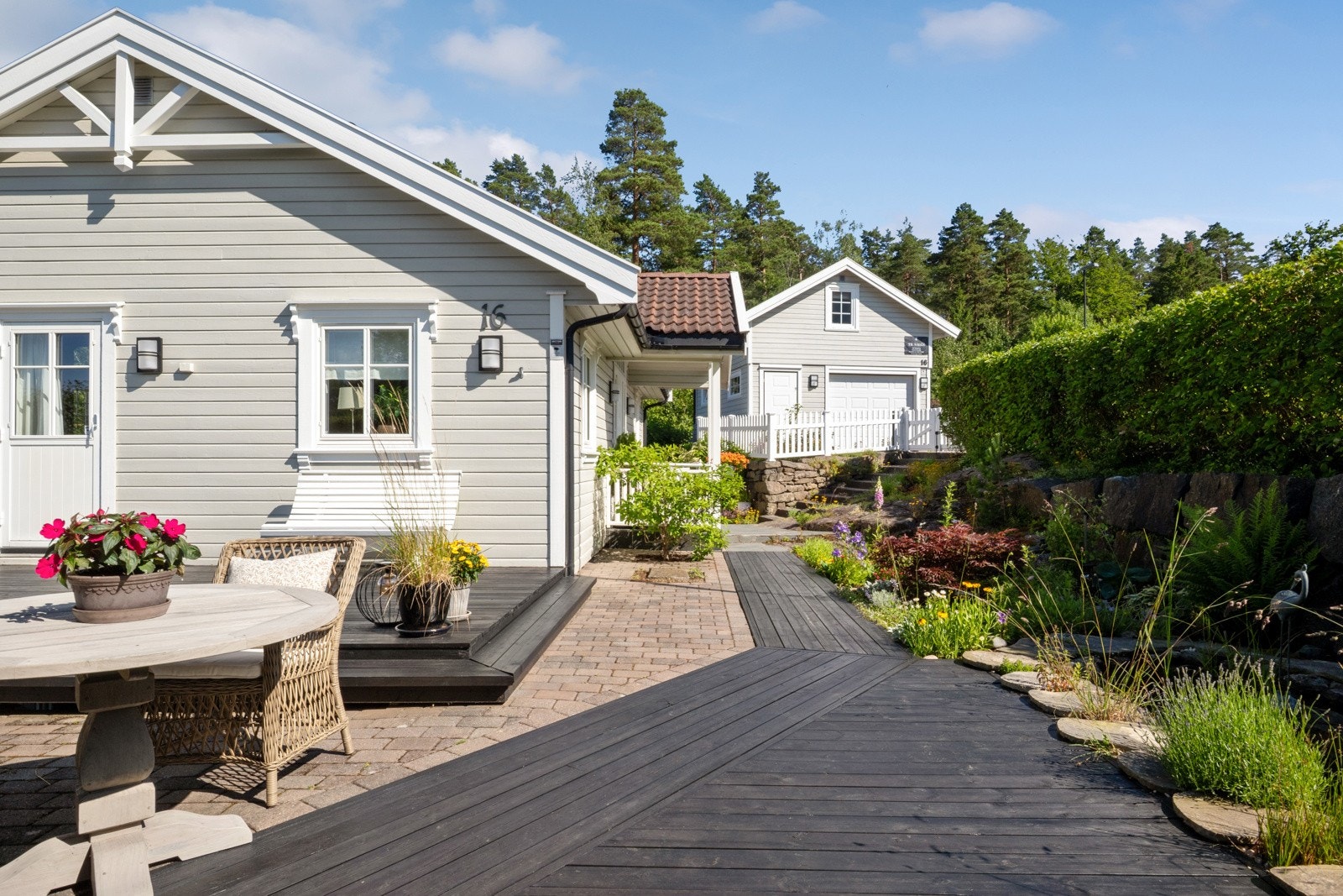 Terrassen har både tre- og steinbelagt dekke, og det er montert stemningsfull utebelysning på husveggen. Galleribilde