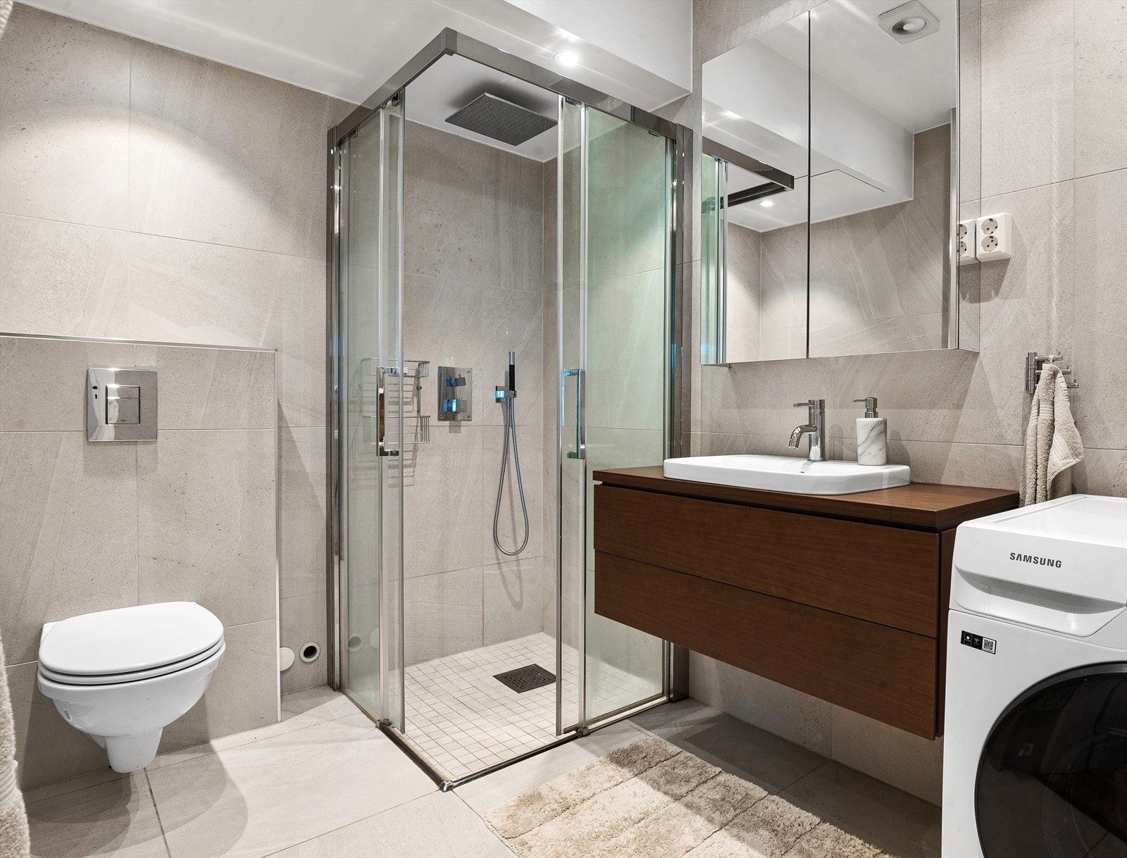 Lekkert baderom fra 2017. Badet har vegghengt toalett og opplegg for vaskemaskin/tørketrommel. Galleribilde