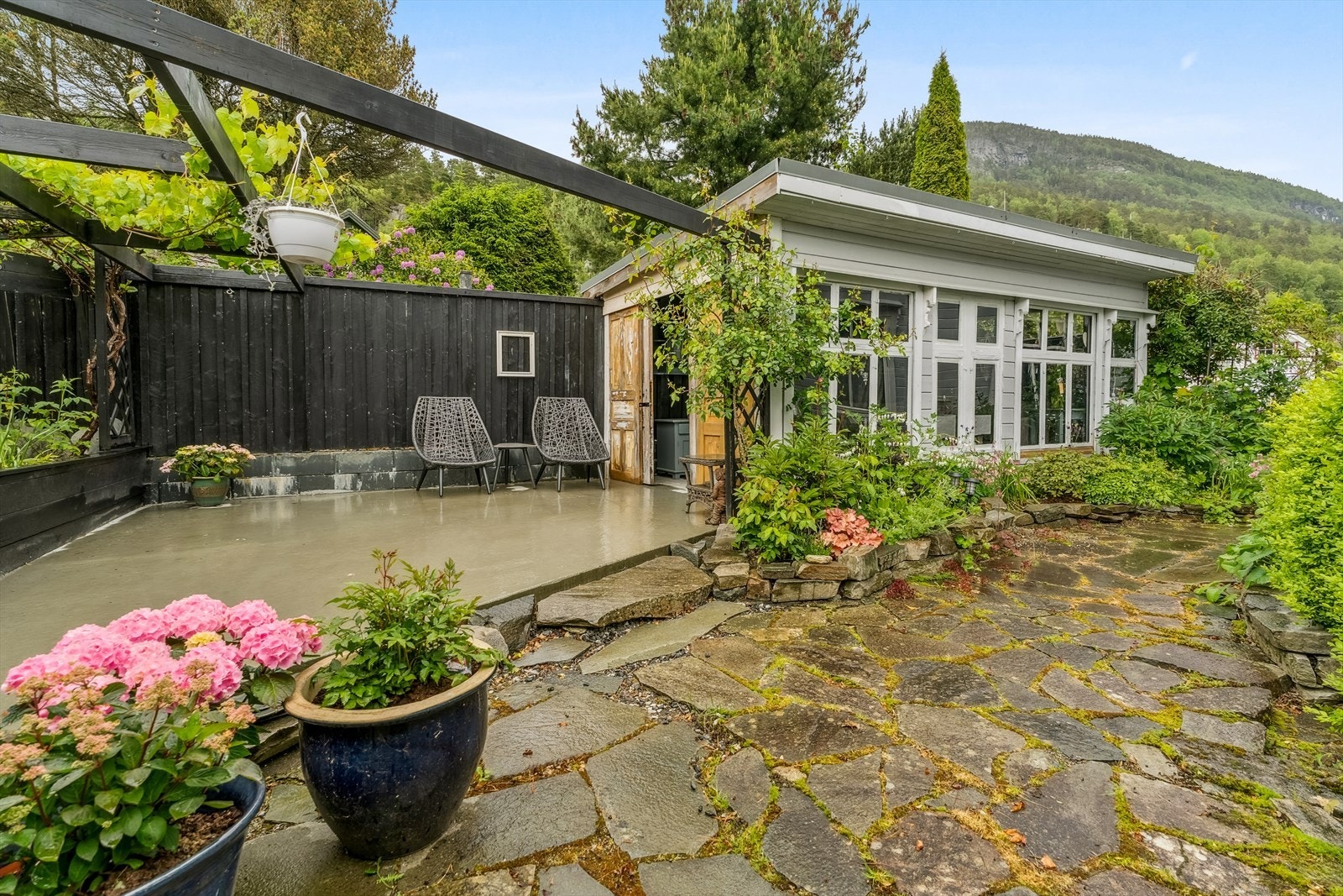 Hagen er tilnærma fullt opparbeidd med terrassar, hellelagte og singla områder, anneks og beplantning, som saman skapar eit lunt og triveleg utemiljø. Galleribilde