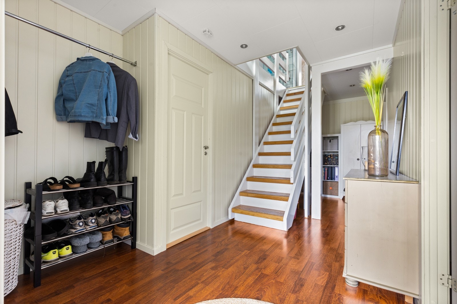 En åpen, lys og delikat entré og trapperom. Et godt rom til å ønske venner og familei velkommen. Galleribilde