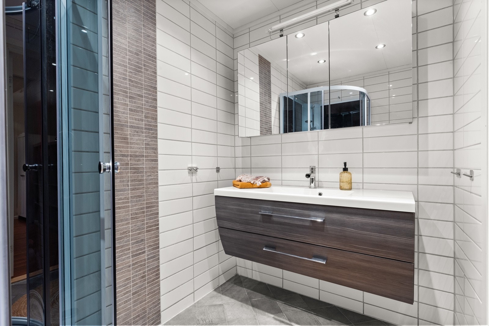 Delikat og romslig baderom. Servant med moderne innredning, speil med overskap i front. Galleribilde