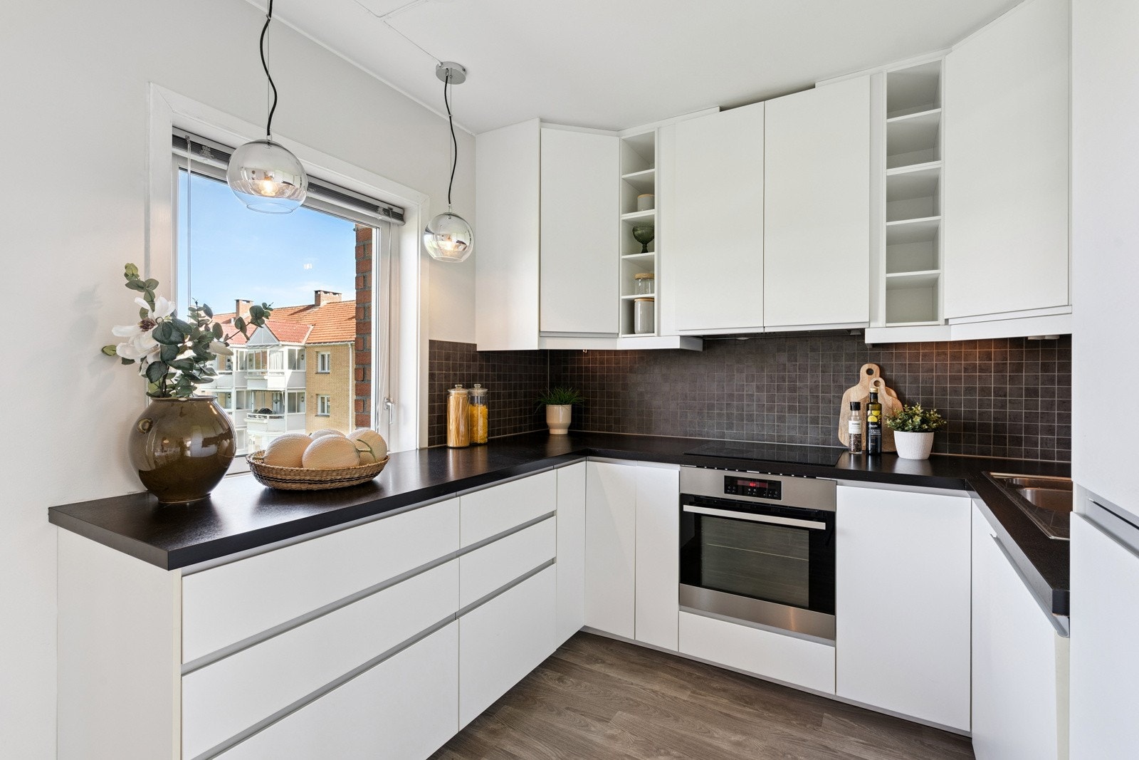 Pent kjøkken fra 2014 med integrerte hvitevarer og åpen spisestueløsning. Galleribilde