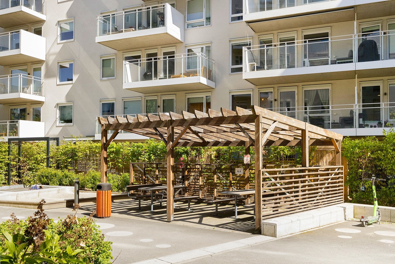 Gårdsrommet er pent opparbeidet med store grøntområder, sittegrupper, stier og lekeområder Galleribilde