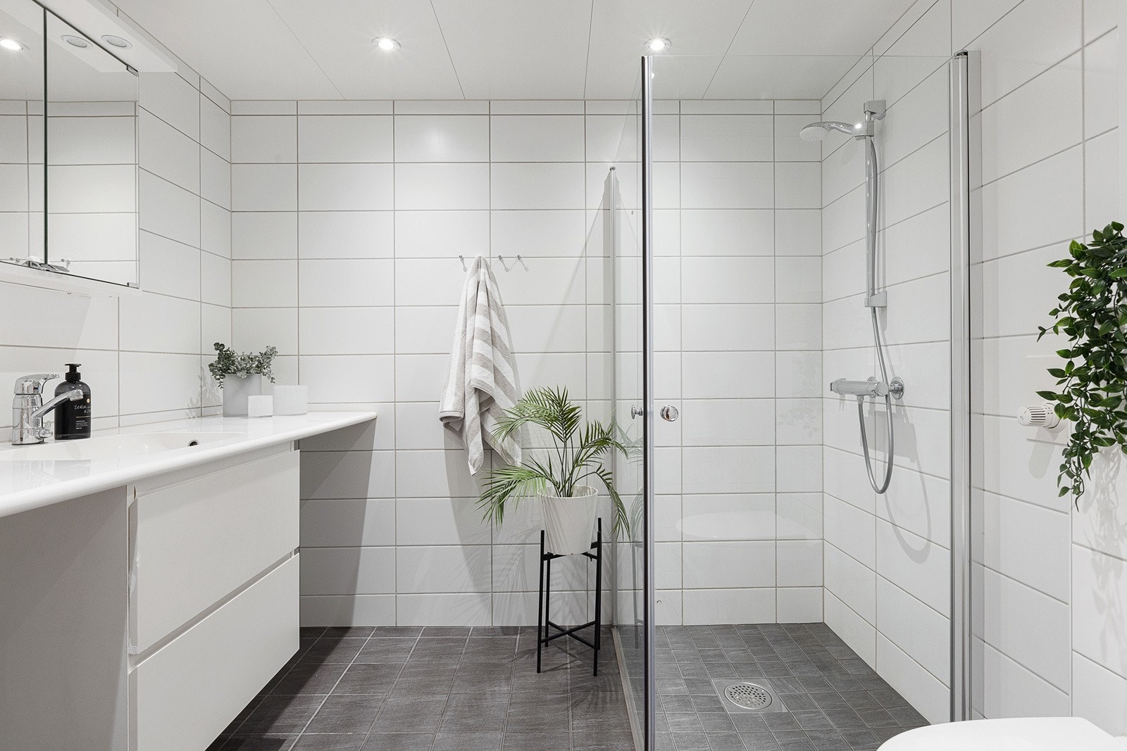 Delikat flislagt bad med downlights i himling og vannbåren gulvvarme Galleribilde