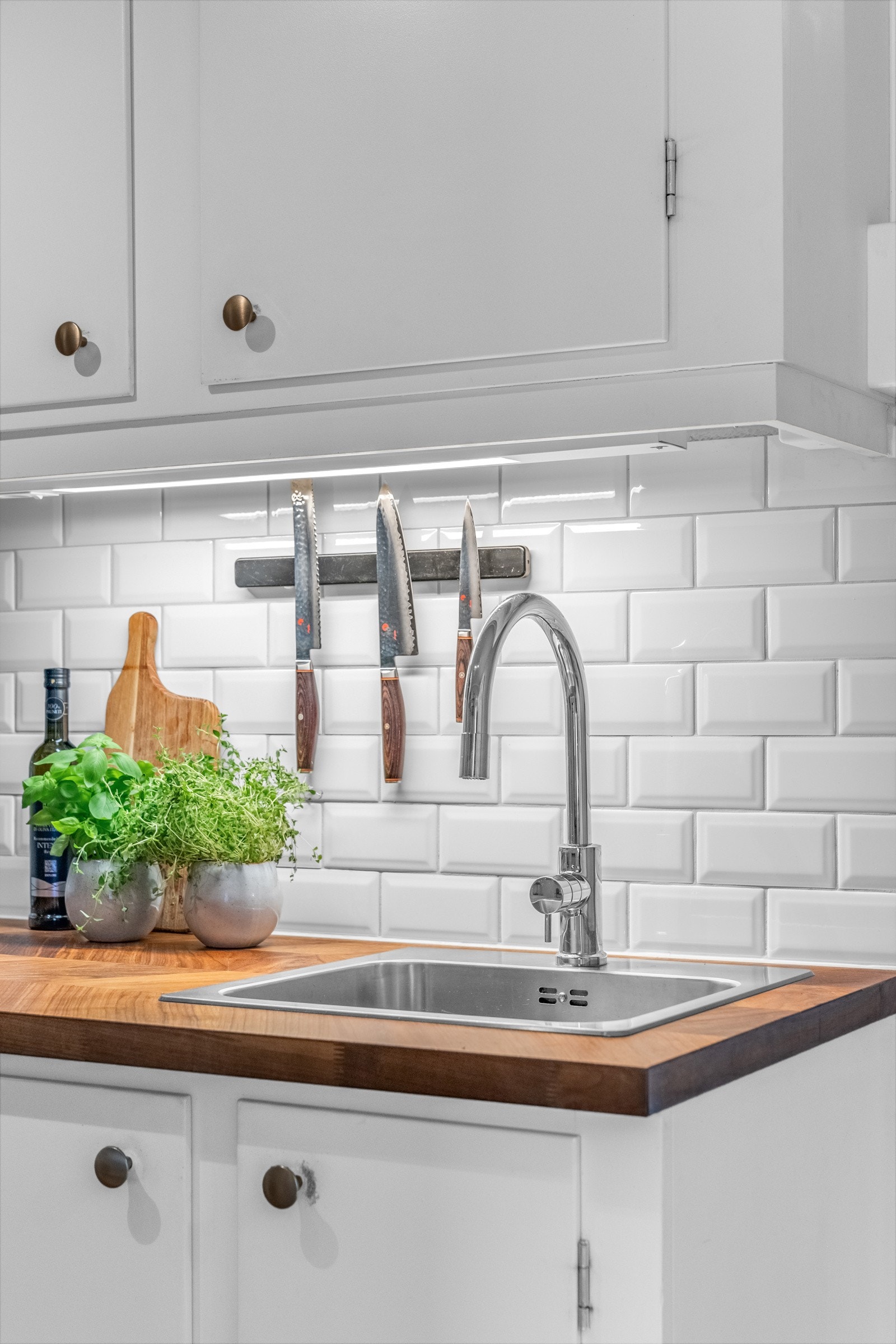 Rommet er innredet med lyse, glatte fronter, fliser over benkeplate av tre og nedfelt oppvaskkum med ett-greps armatur, i tillegg til benkeskapsbelysning og stikkontakter over benkeplate. Galleribilde