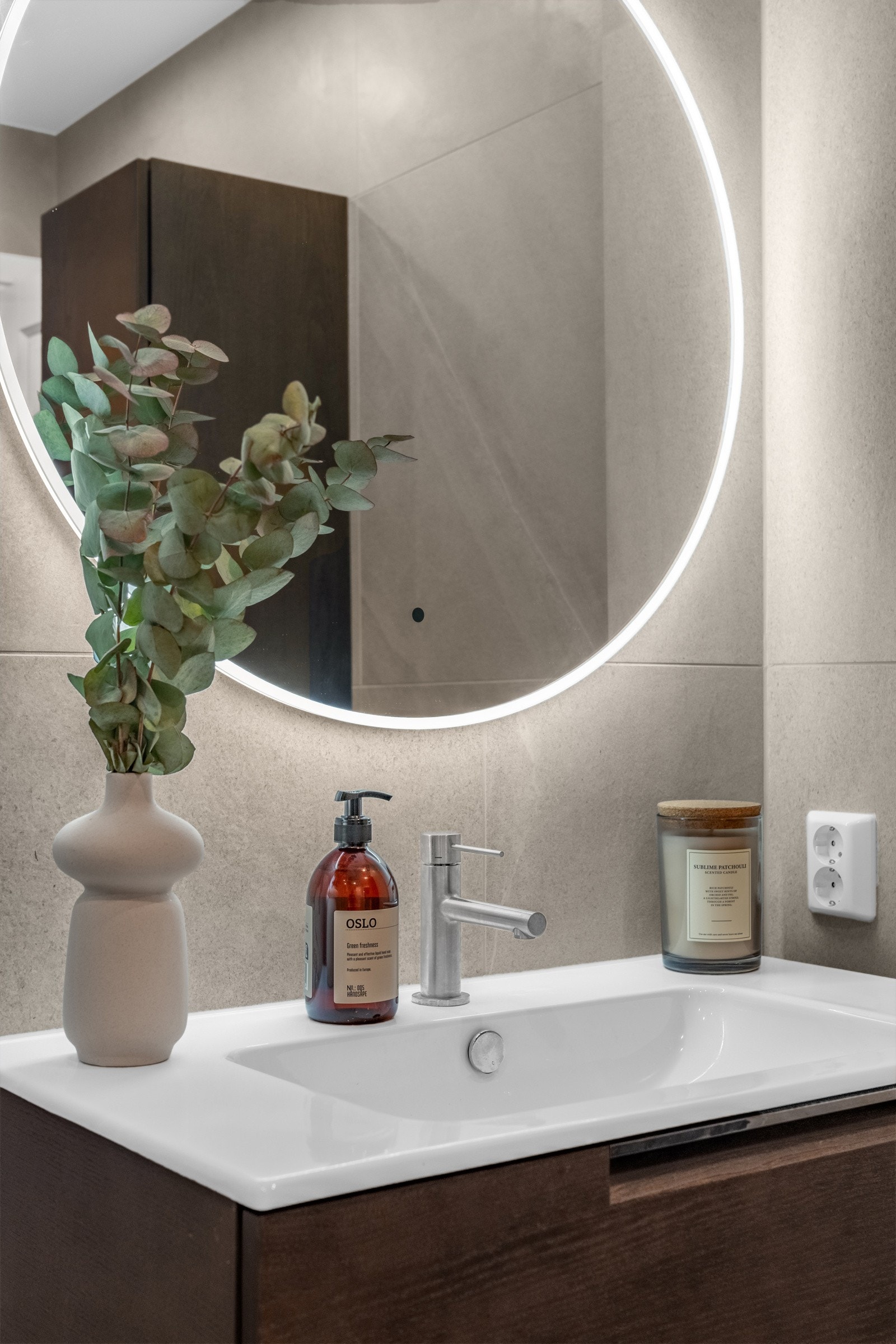 Baderommet har vegghengt servantinnredning med skuffer, ovenpåliggende servant med ett-greps armatur, og speil med dimbar lysramme. Galleribilde