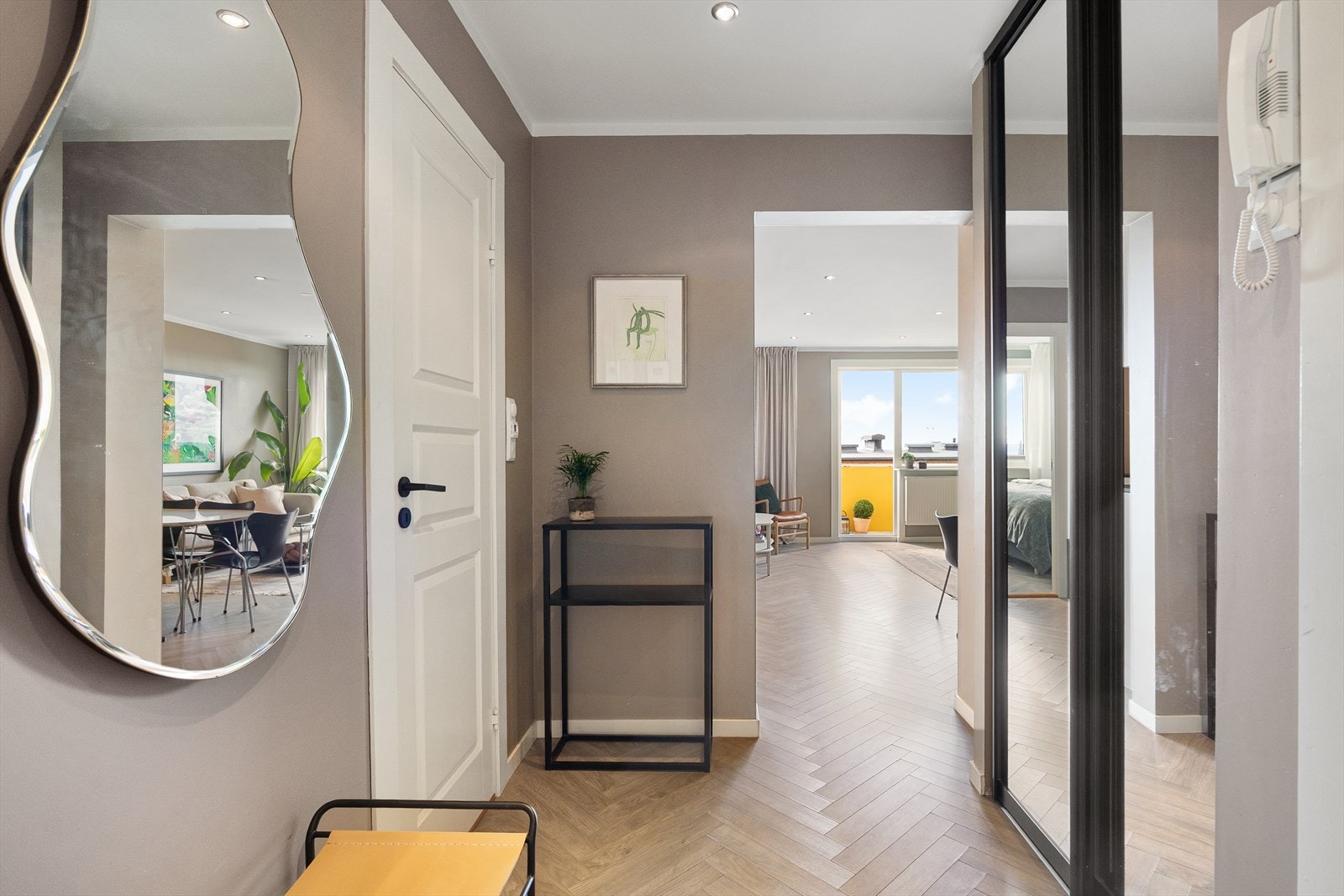 Velkommen inn! Her blir du møtt en av romslig og innbydende entré med god plass til lagring i en skyvedørsgarderobe med speilskap. Galleribilde
