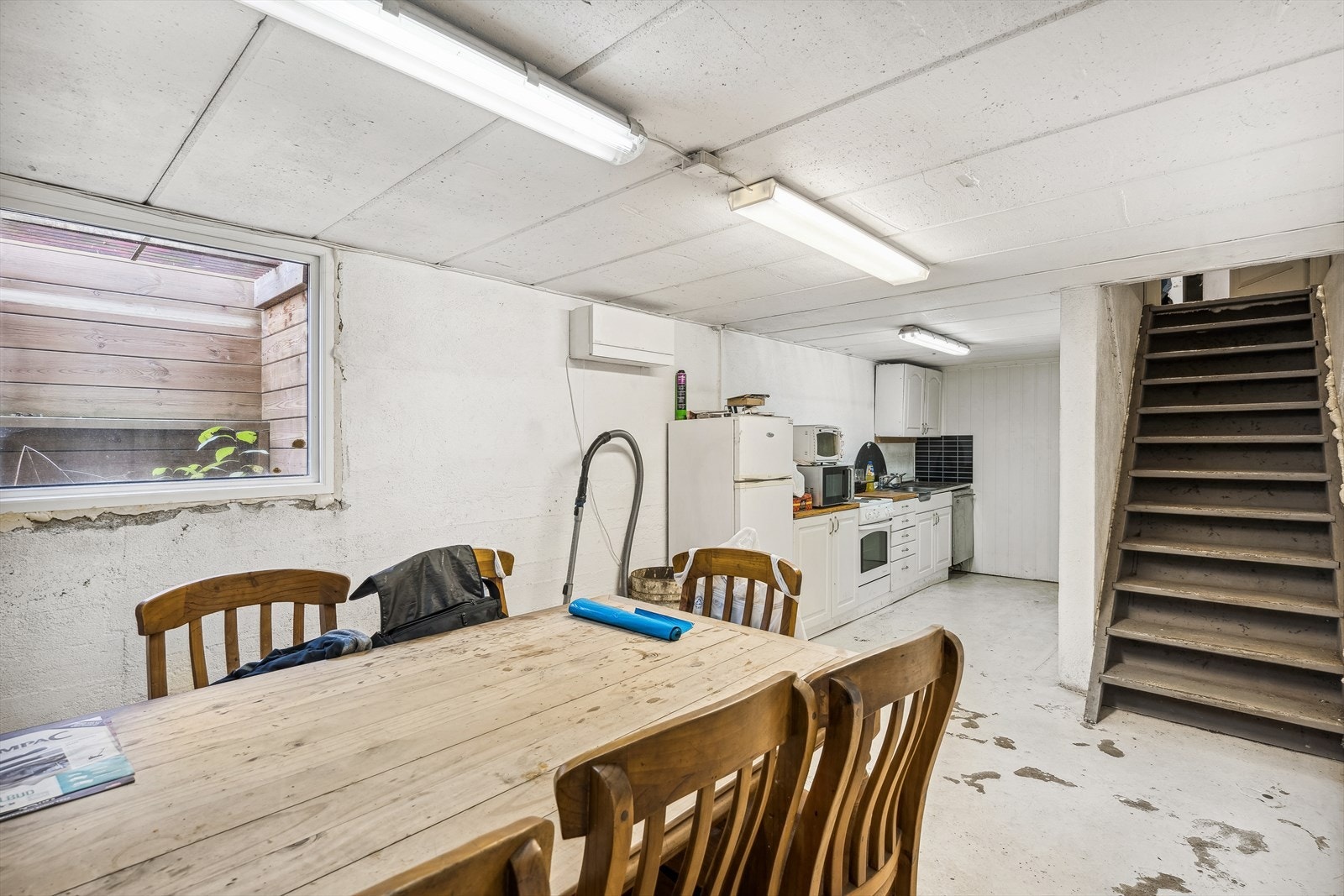 Kjeller i verkstedet innredet med spiserom og kjøkkendel. Galleribilde